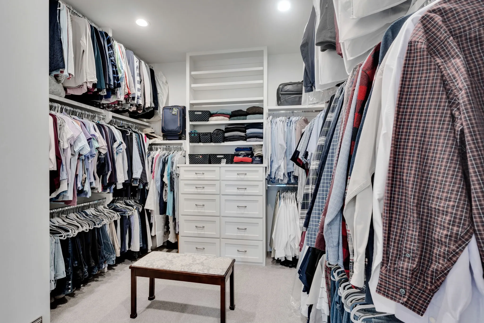 Walk in closet with light colored carpet