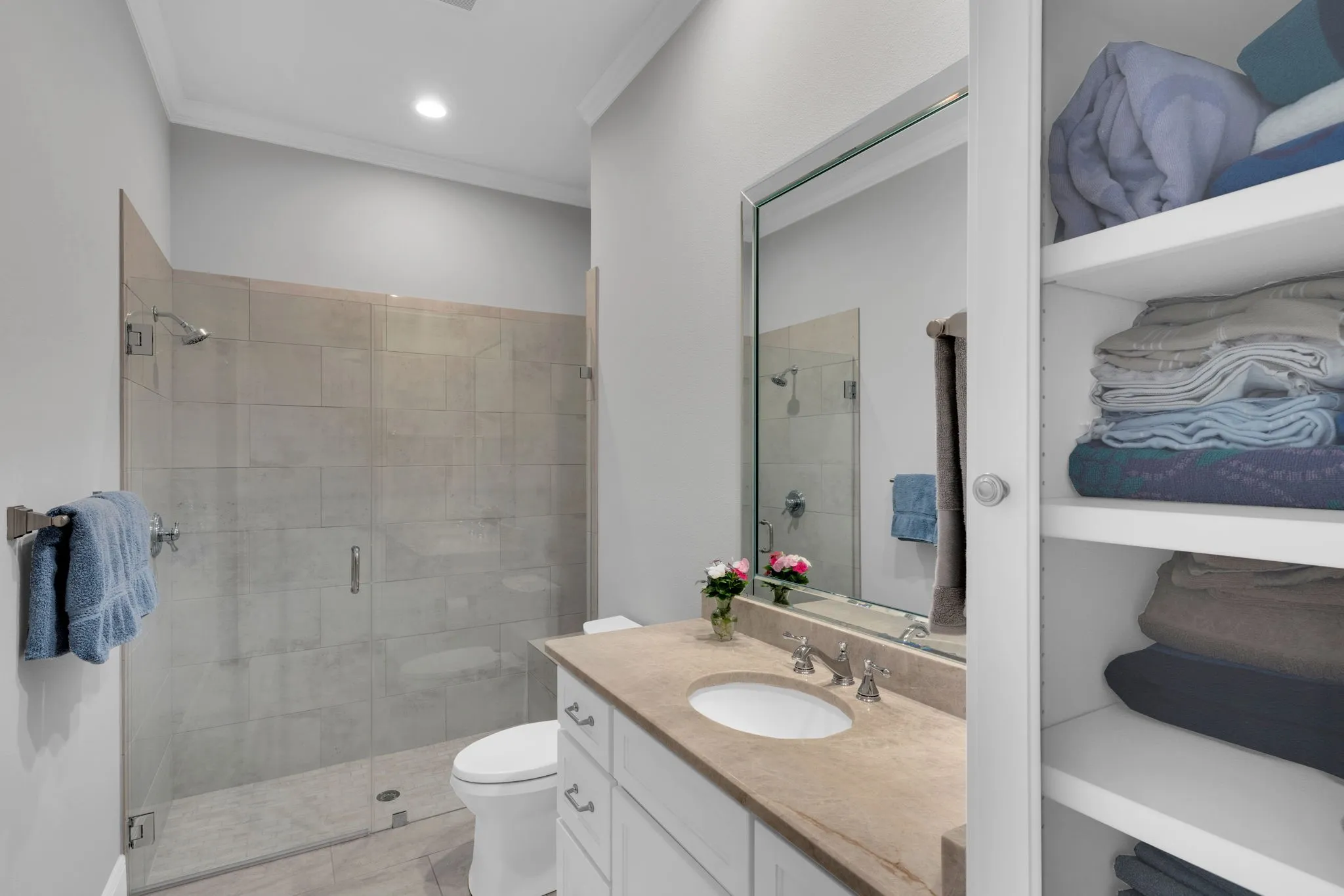 Full bath featuring vanity, crown molding, and a shower stall