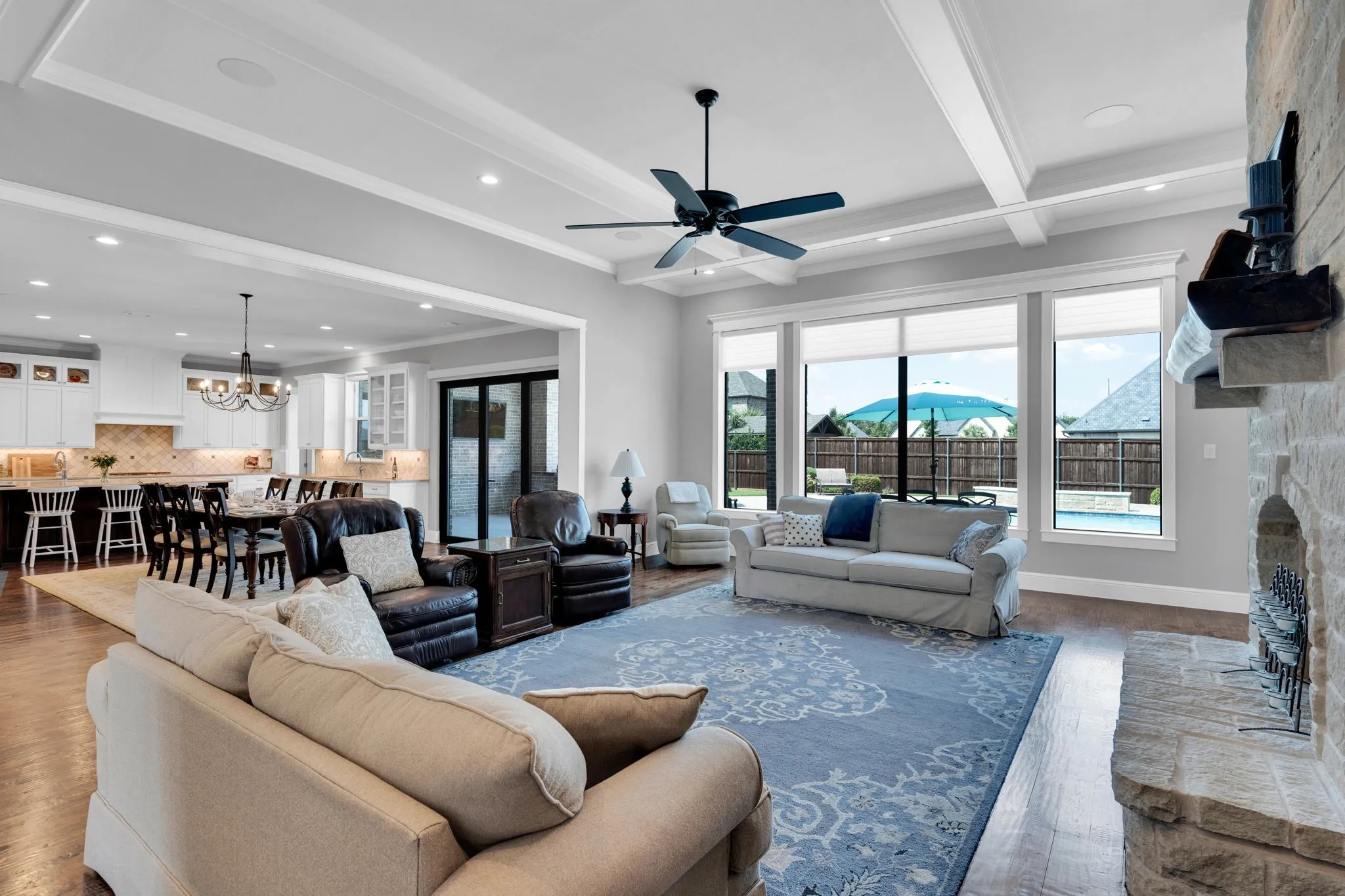 Living room with beam ceiling, a fireplace, wood finished floors, ceiling fan, and recessed lighting