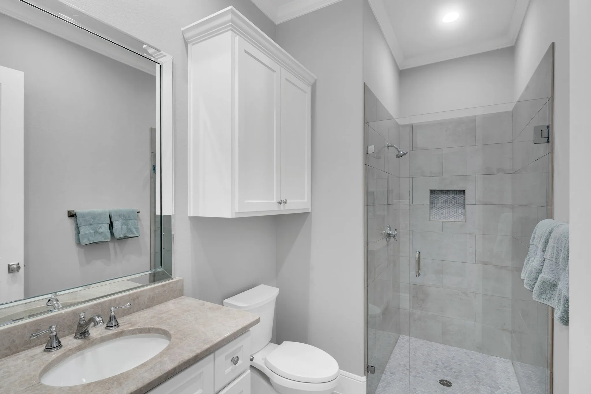 Bathroom with a shower stall, vanity, and ornamental molding