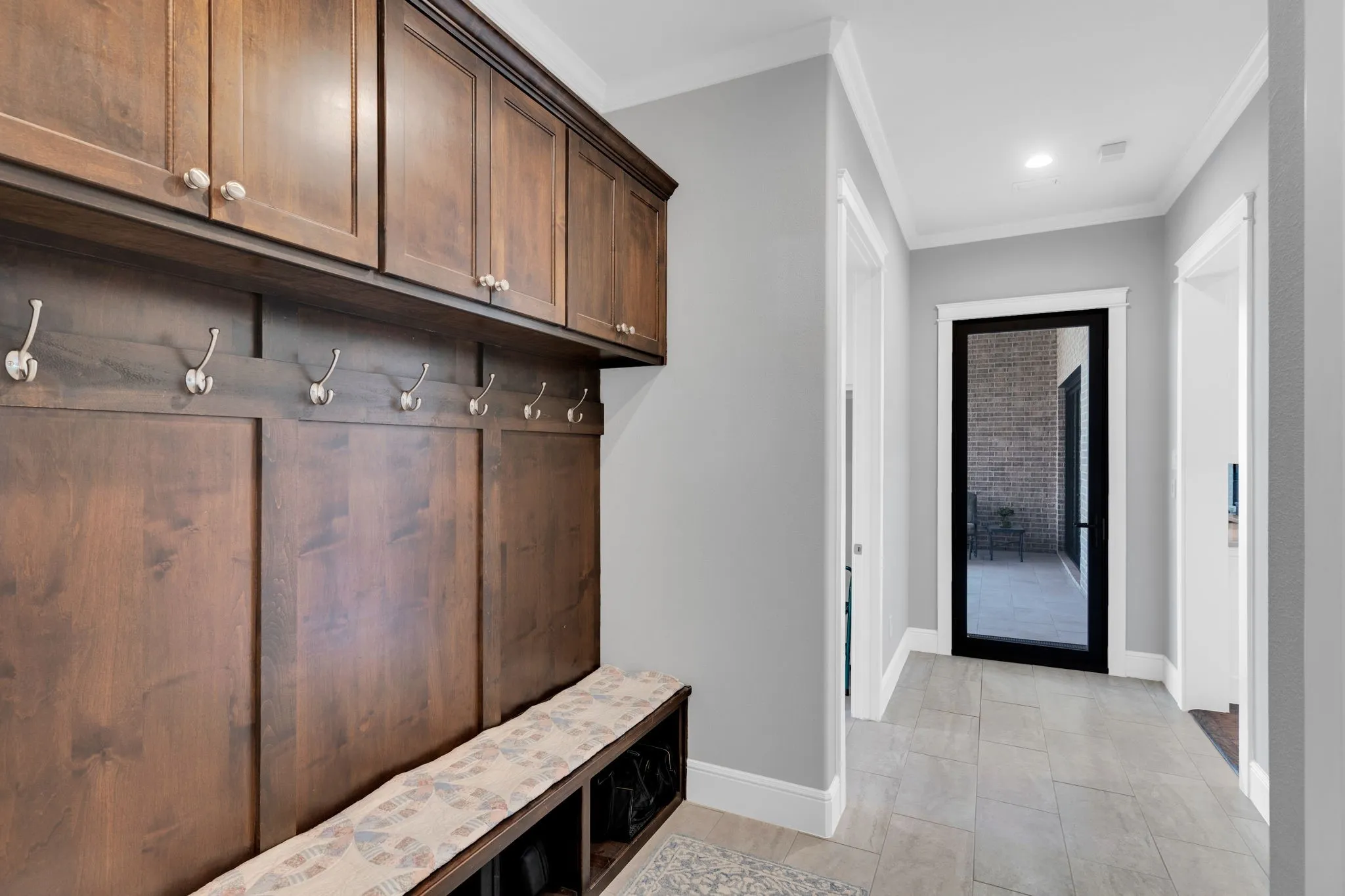 Mudroom featuring crown molding and light tile patterned floors