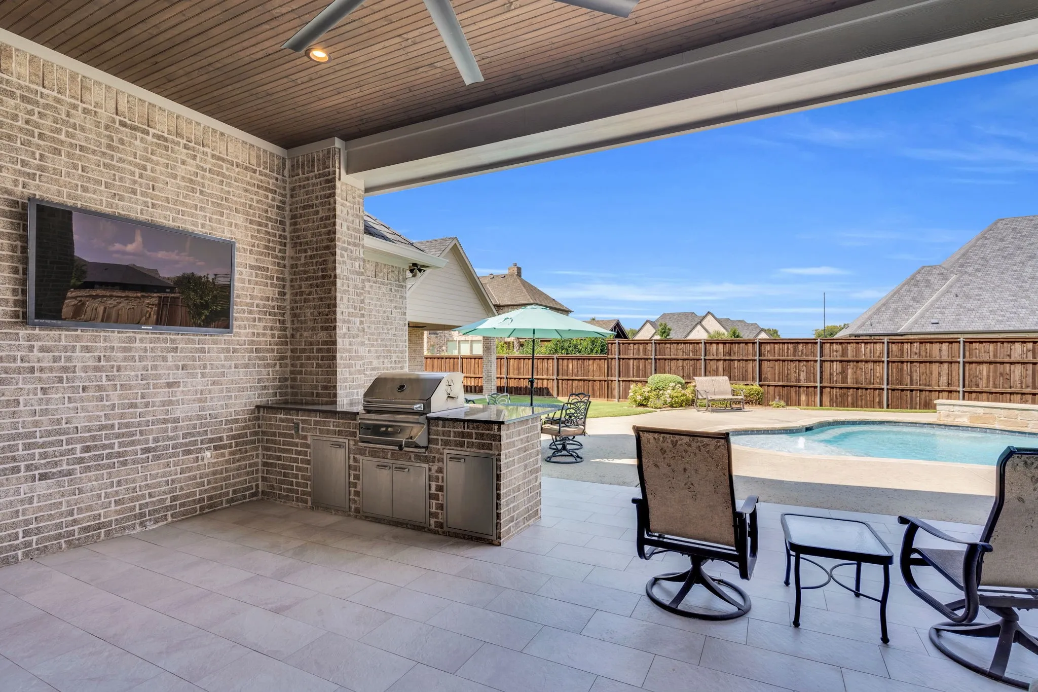 Fenced backyard with a patio area, area for grilling, and a ceiling fan