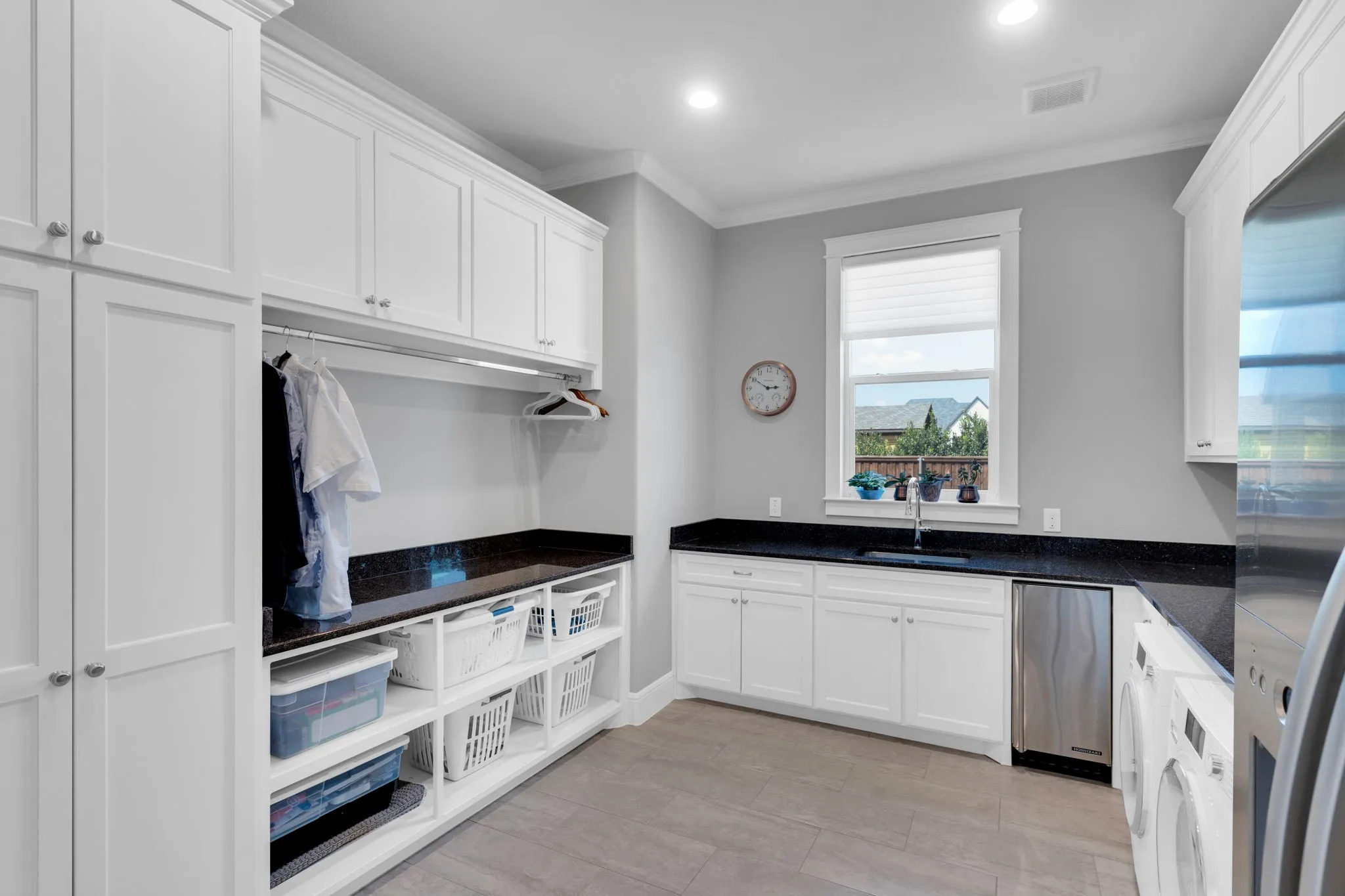 Kitchen with white cabinets, crown molding, dark stone counters, freestanding refrigerator, and recessed lighting