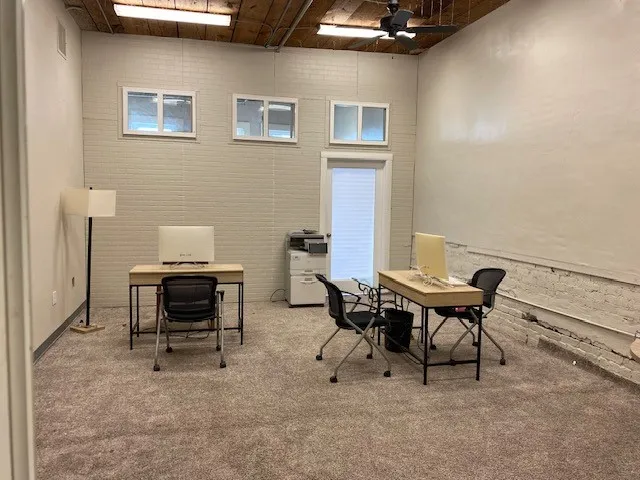 Office with ceiling fan and brick wall