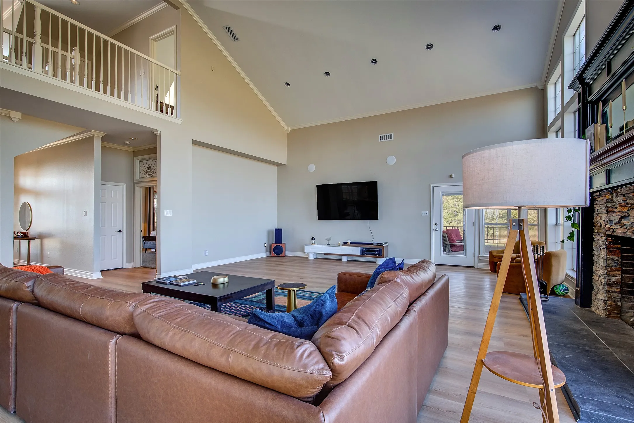 Living room has glass door to back porch, loft overlook, vaulted ceiling.