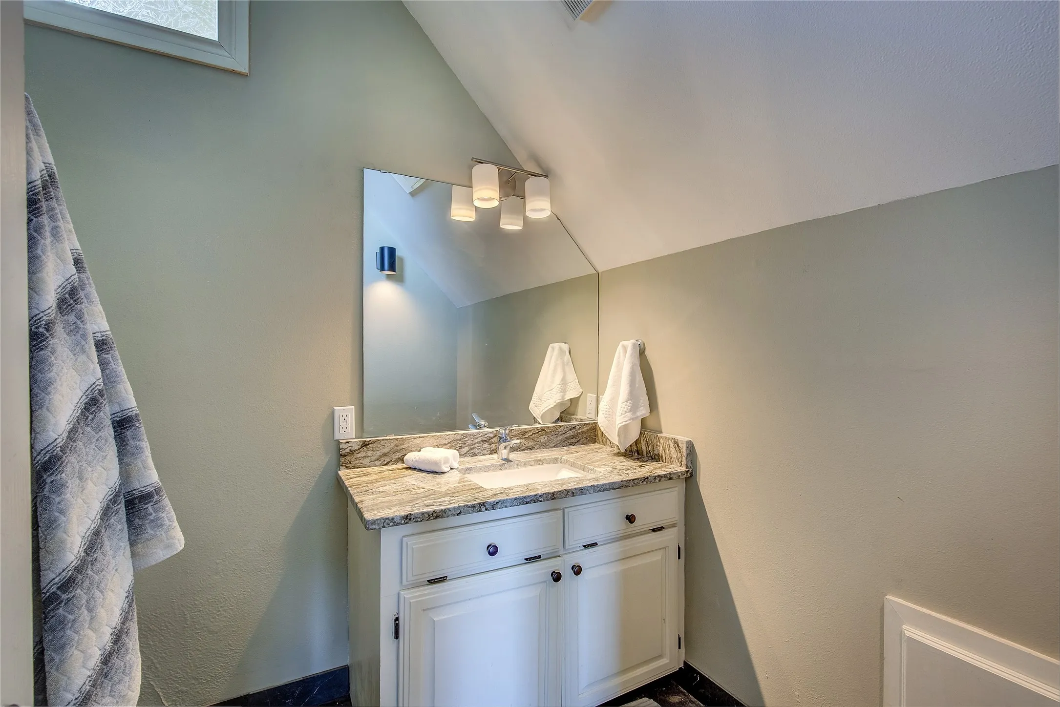 Bath in guest quarters has granite top, tiled shower with body sprays.