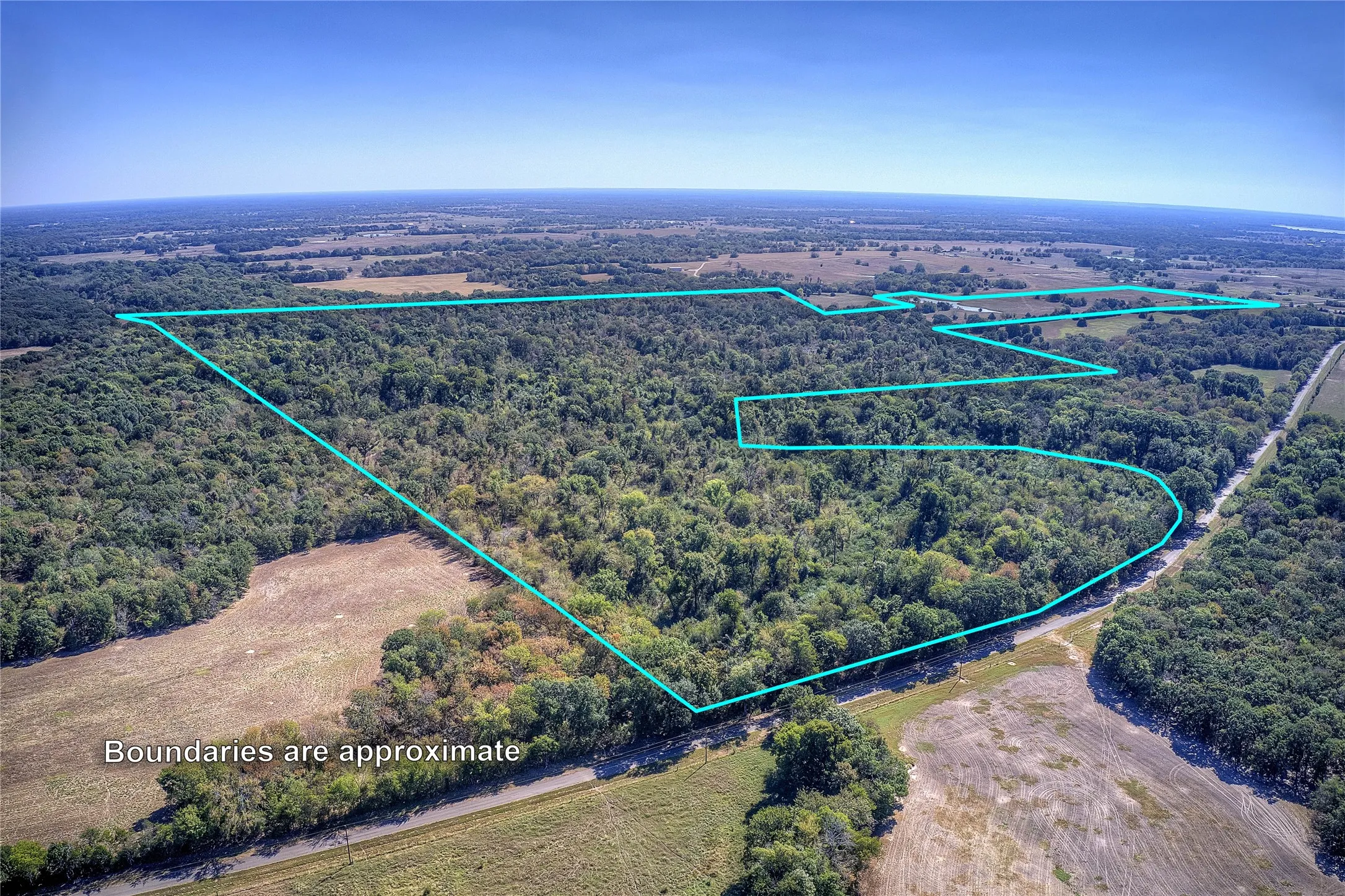 County Road frontage-- Aerial view with approximate boundaries drawn, from the north of the property looking roughly south.