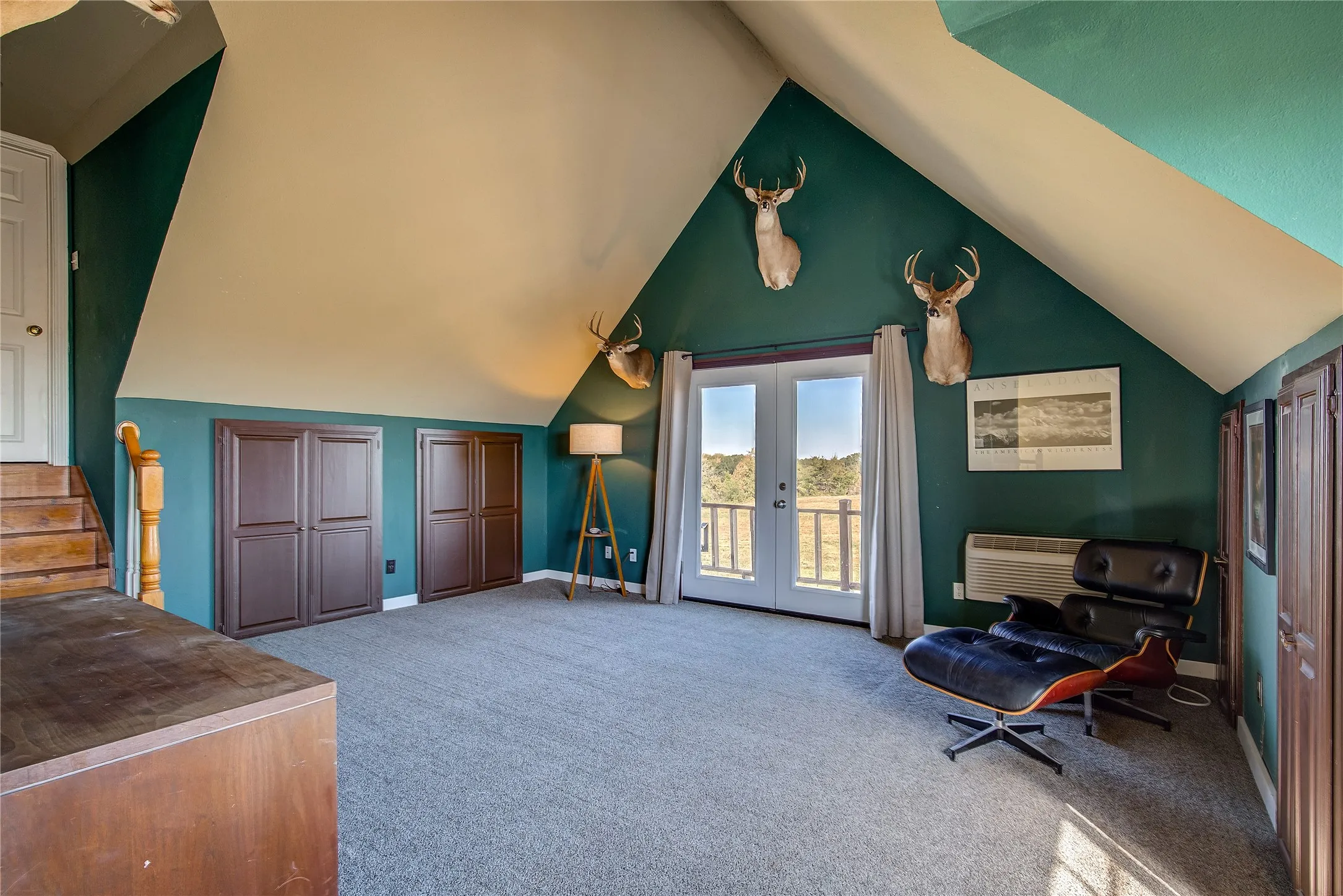 Man cave or Guest suite above the garage has french doors to a private balcony with views of the pond.