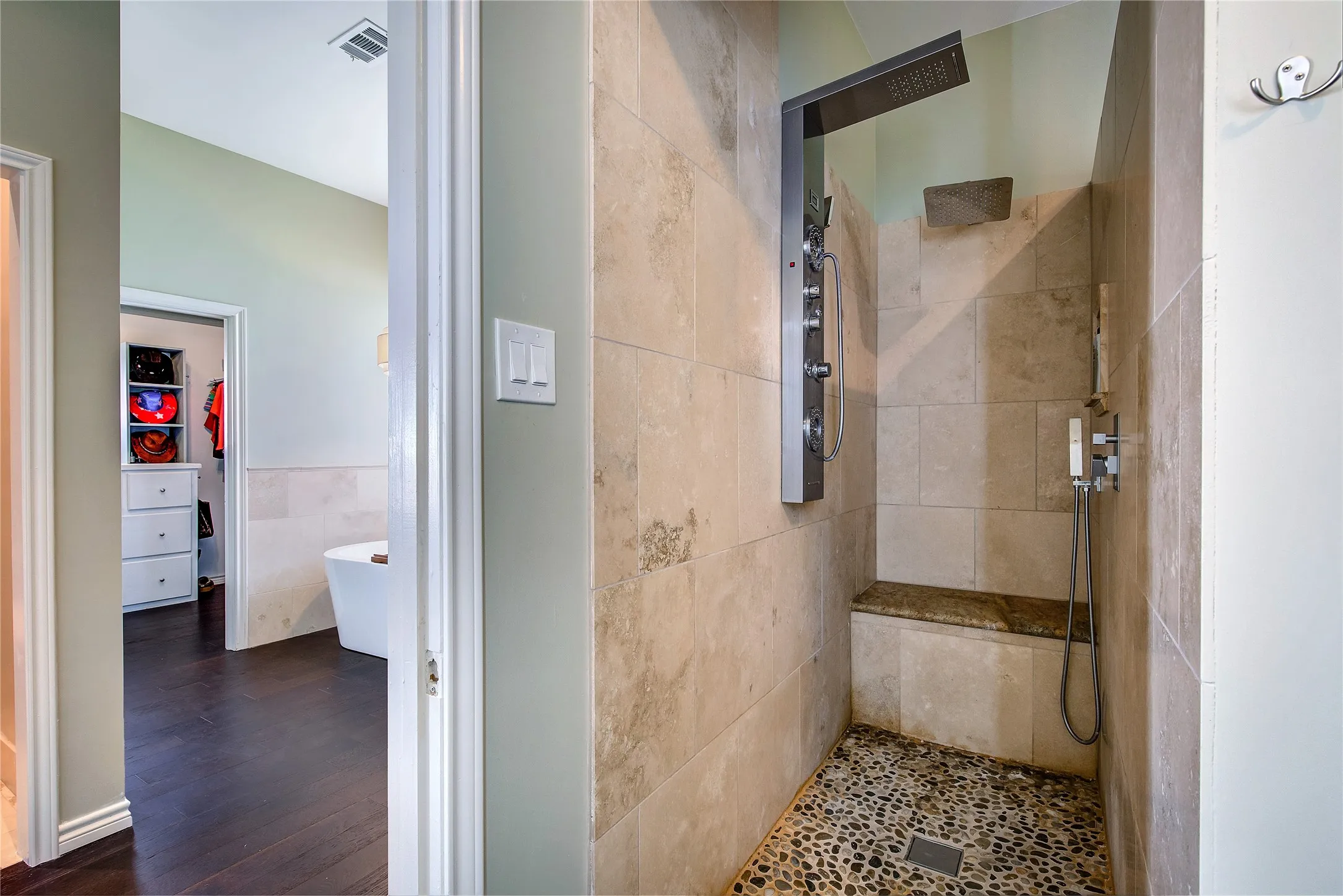Tiled shower with body sprays.