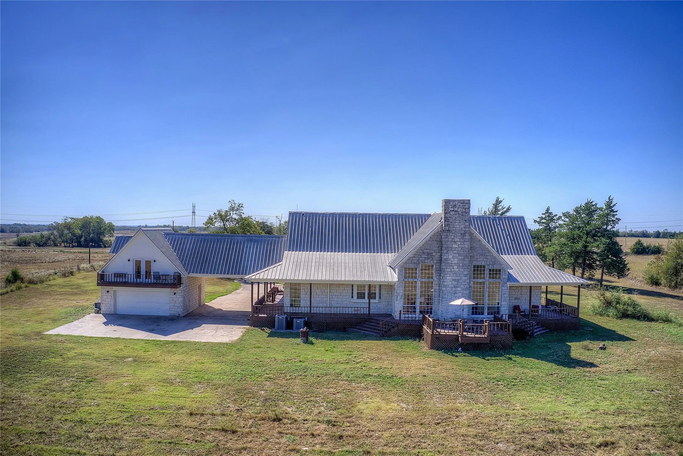 View of back of house and guest quarters, showing deck, carport and garage.