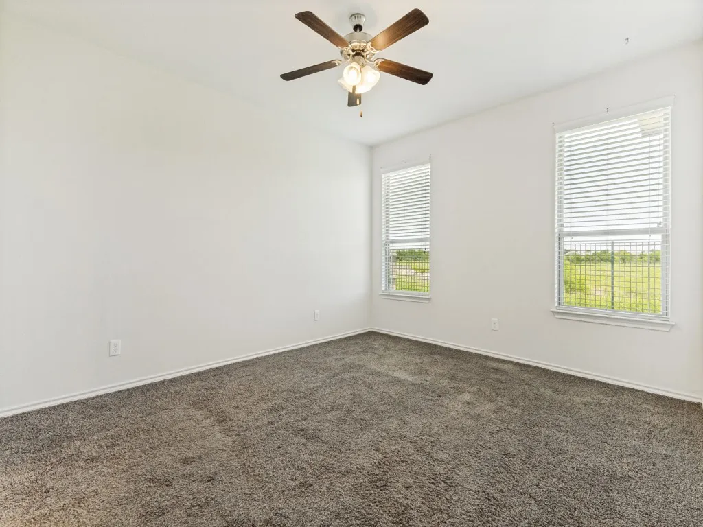 Spacious room featuring neutral carpeting and white walls