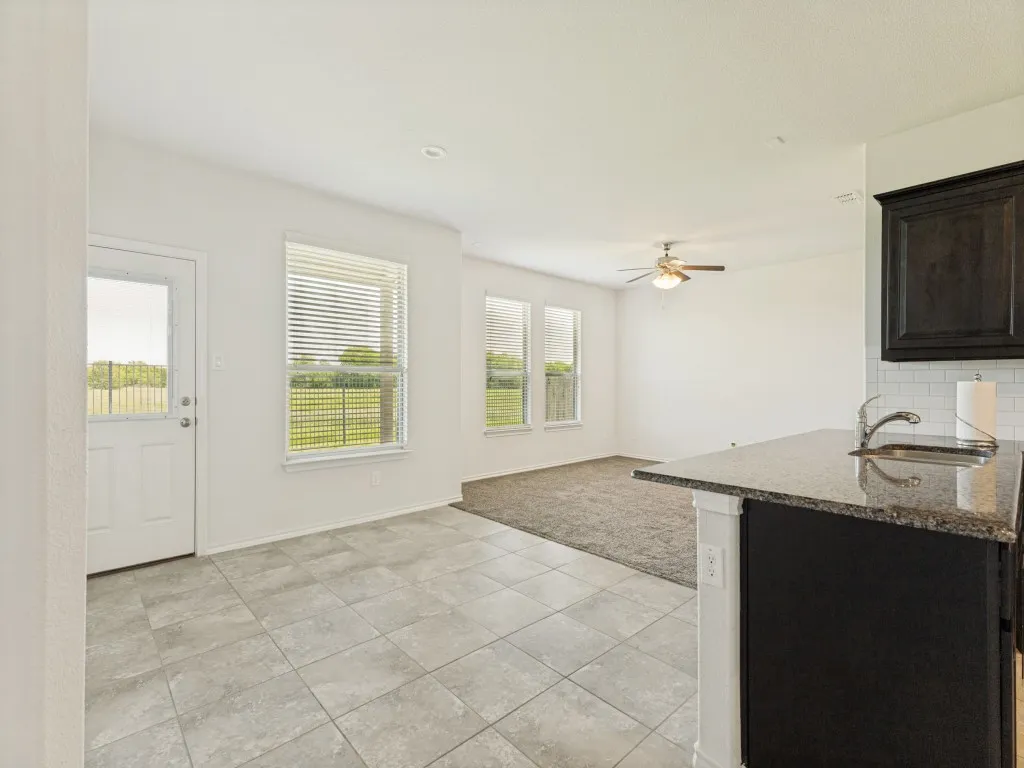 Kitchen island featuring a granite countertop, undermount sink, and chrome faucet