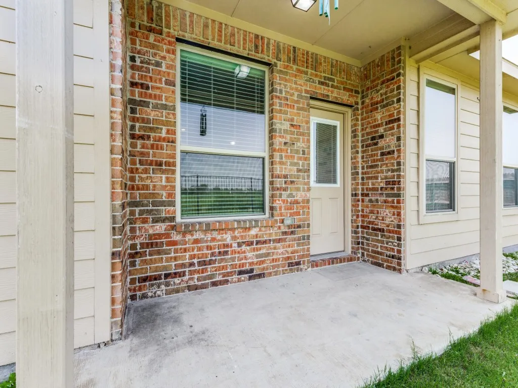 Expansive concrete patio area with brick and siding exterior