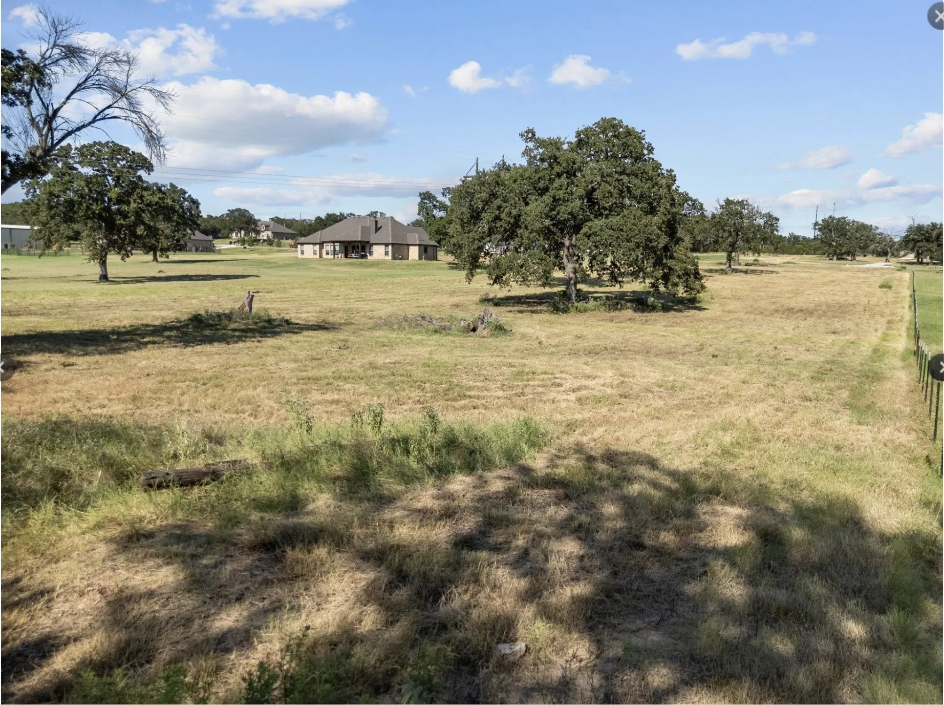 View of green lawn with a rural view