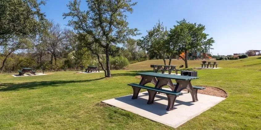 View of property's community featuring a patio area and a lawn