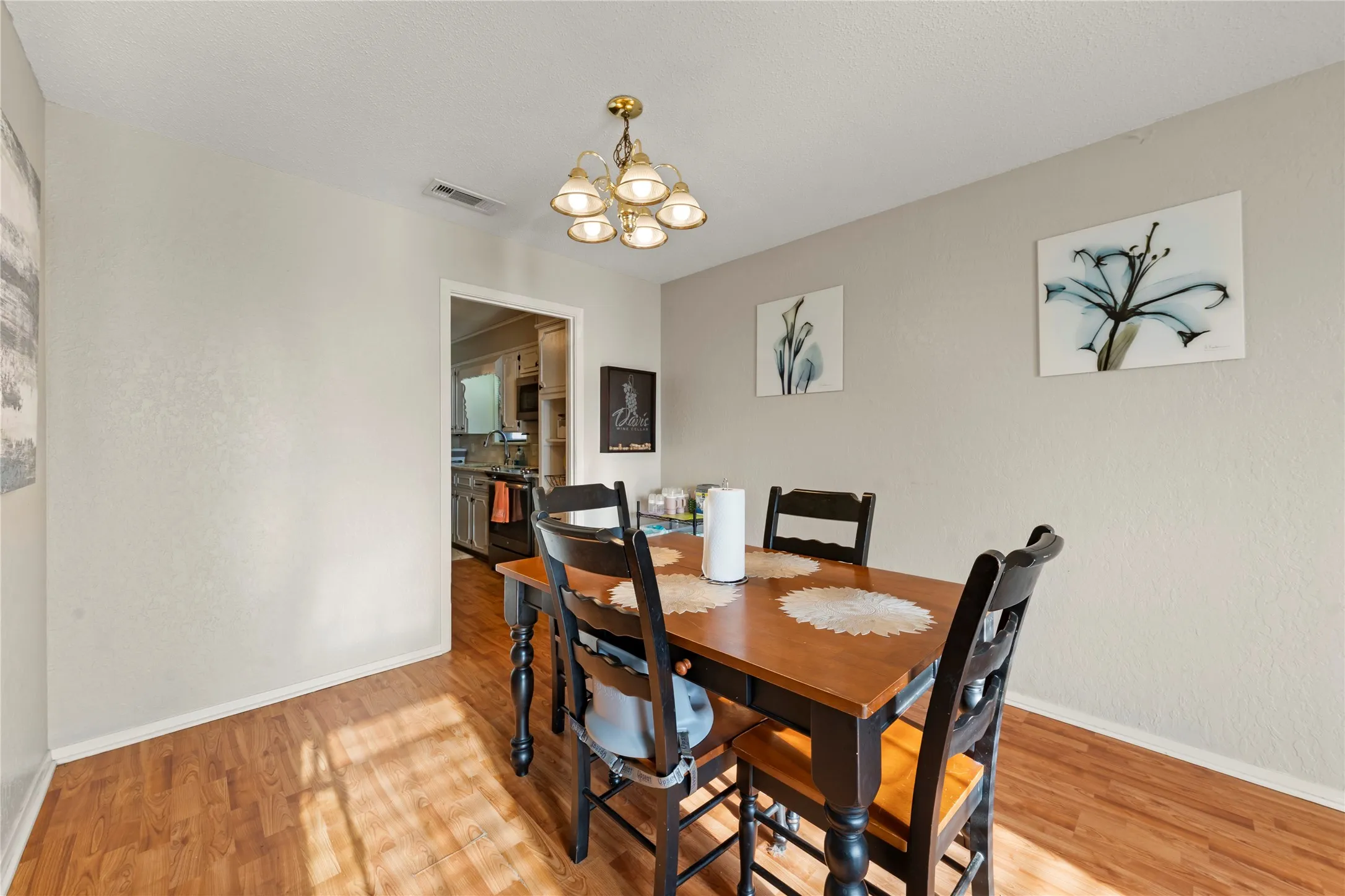 Dining area with light wood-type flooring and a chandelier