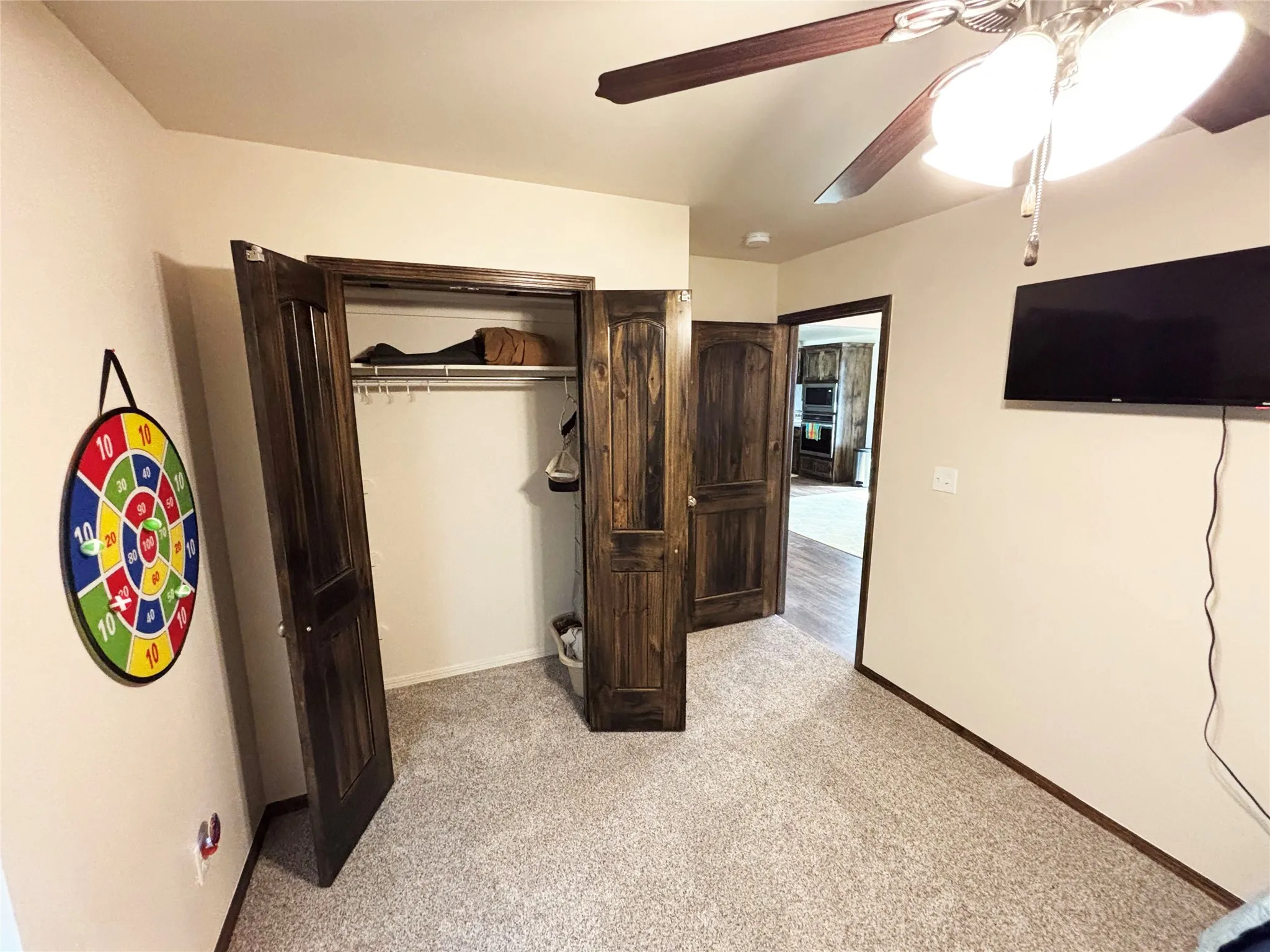 Bedroom featuring light colored carpet, a closet, and ceiling fan