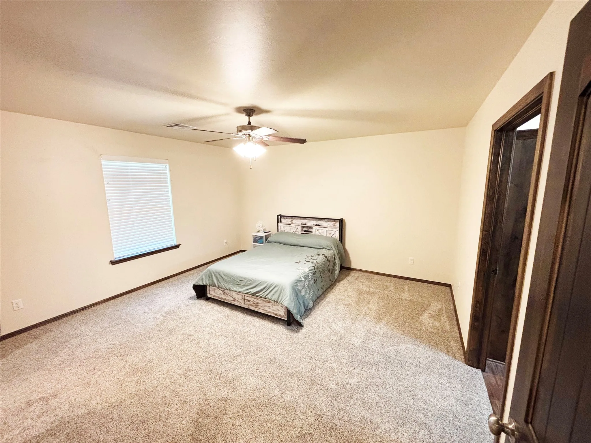 Carpeted bedroom featuring baseboards and a ceiling fan