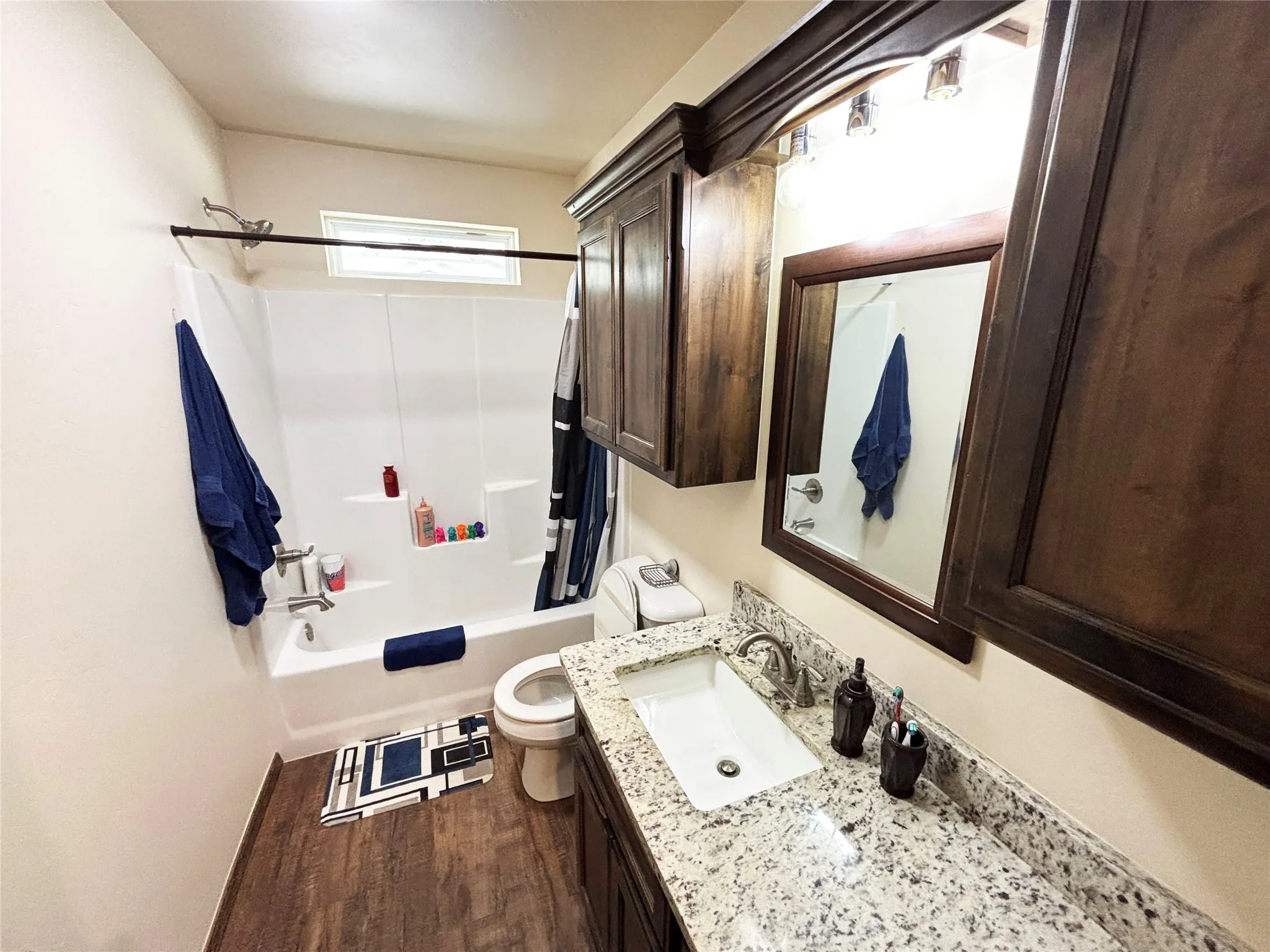 Bathroom featuring vanity, dark wood-type flooring, and shower / tub combo with curtain