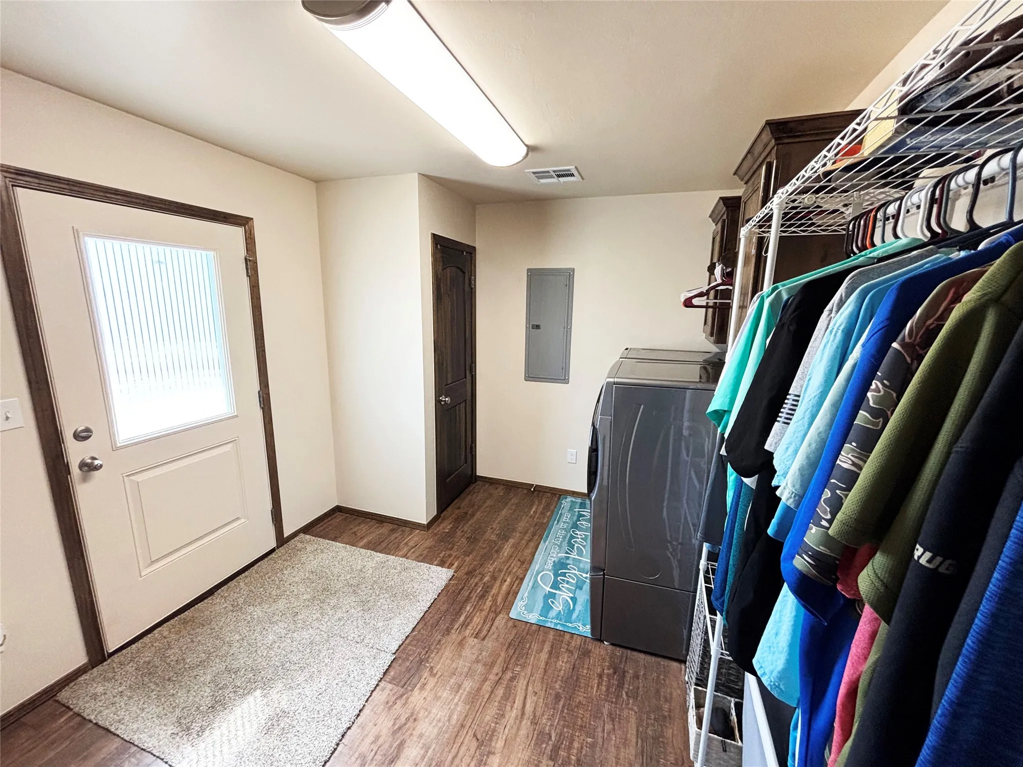 Laundry area with washer / clothes dryer, dark wood finished floors, and electric panel