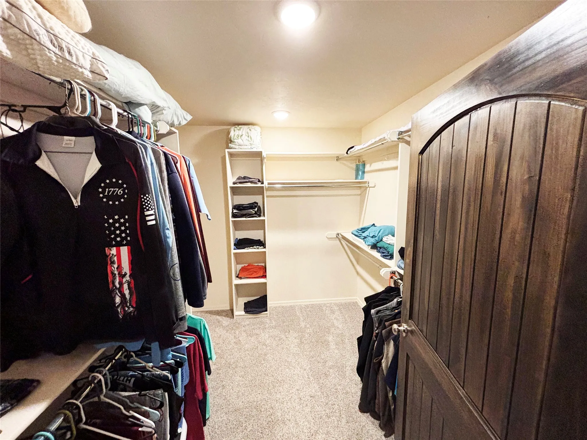 Spacious closet with light carpet