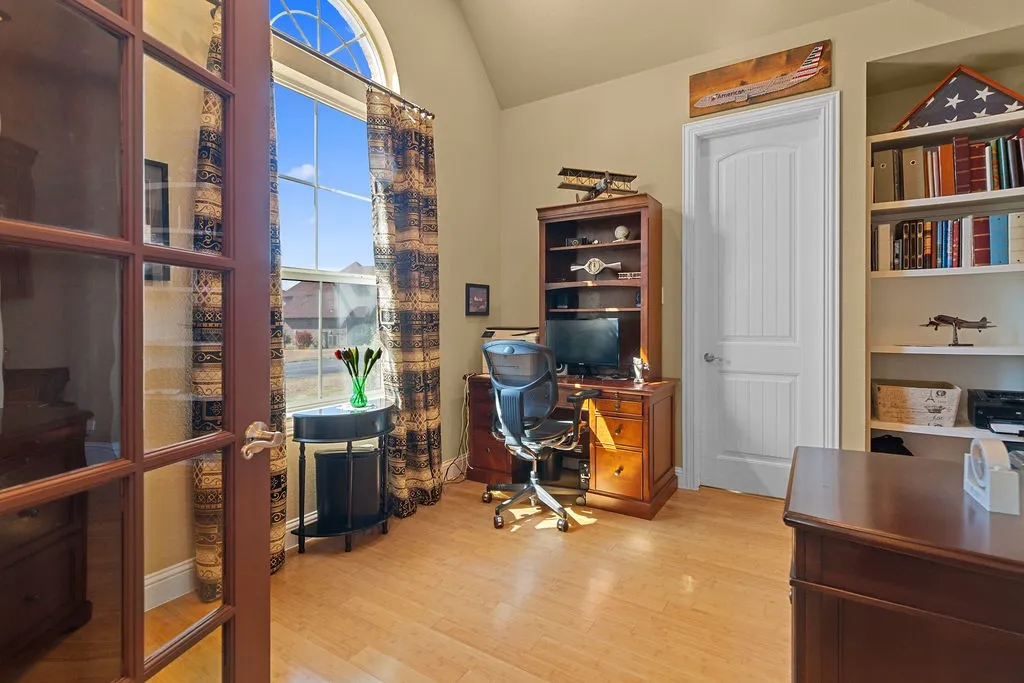 Office area with light wood finished floors and lofted ceiling