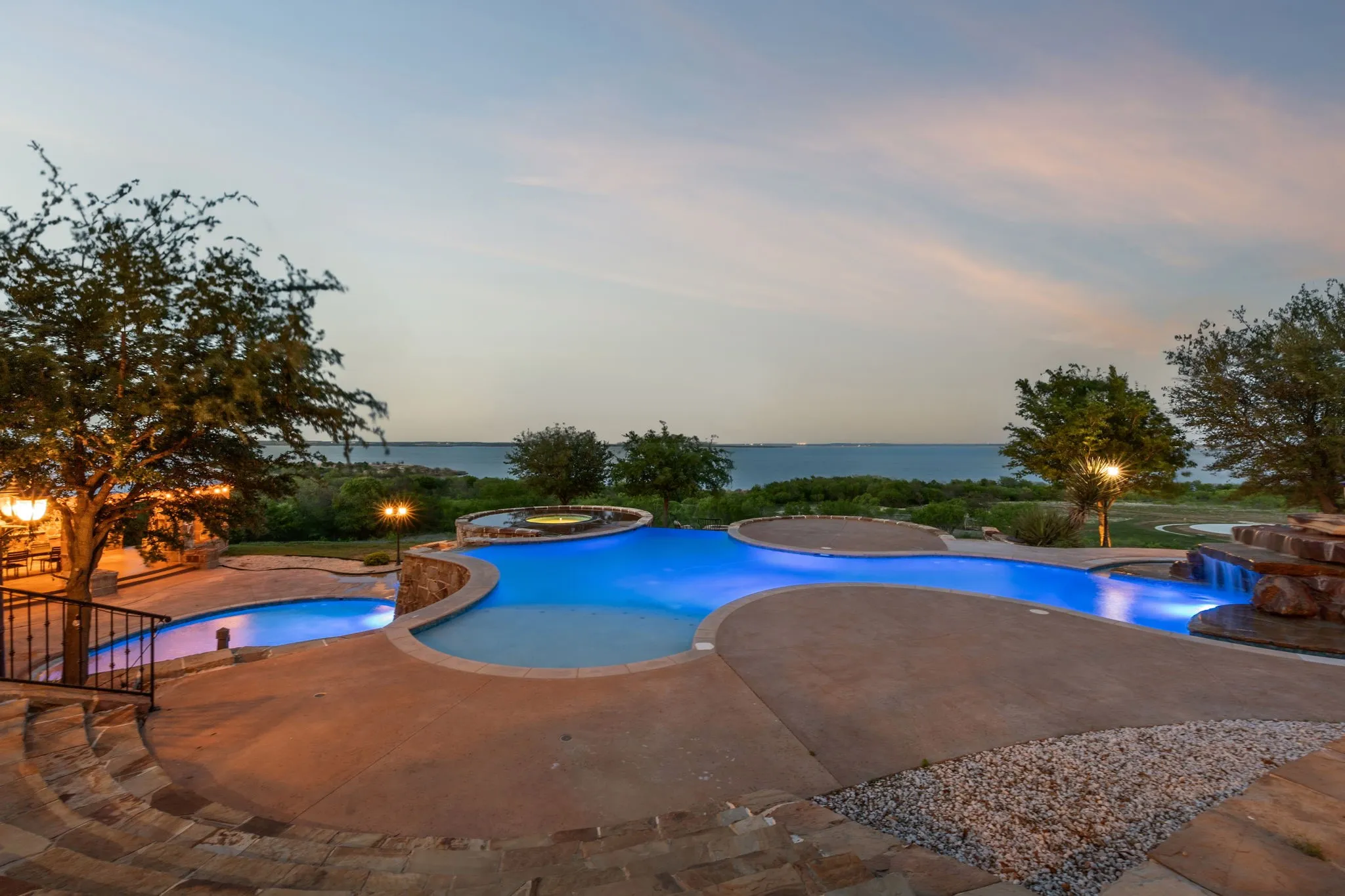 Multi-tiered pool with integrated spa and rock waterfall feature