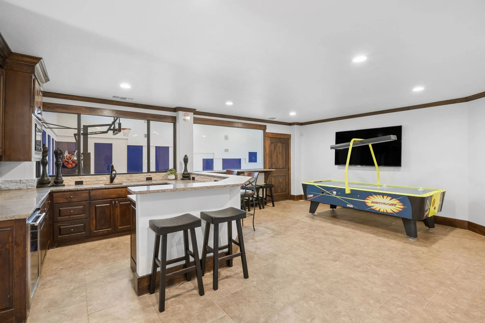 Entertainment space featuring a built-in wet bar with dark wood cabinetry and light-toned countertops