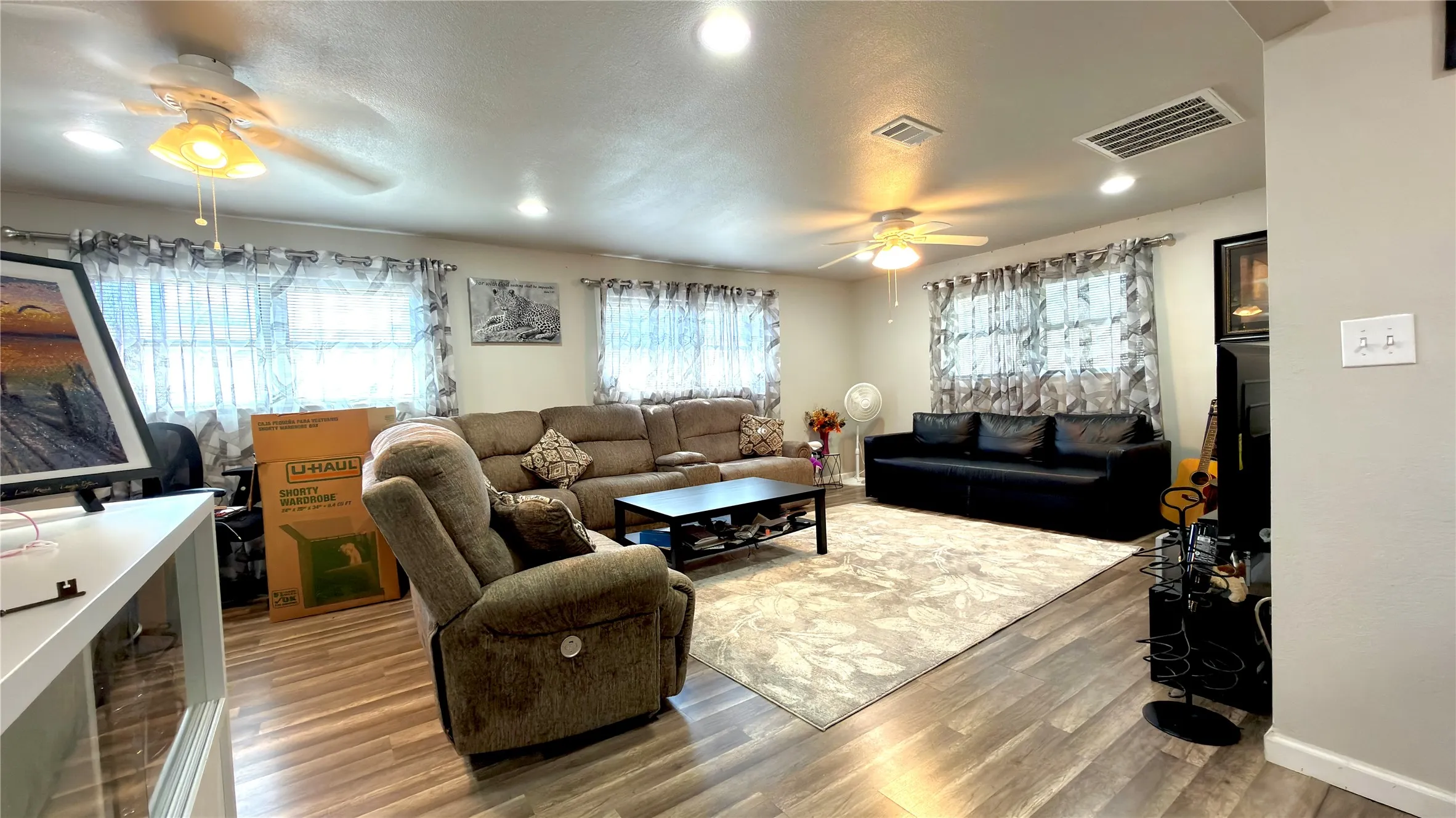 Living room with light wood-type flooring and a ceiling fan