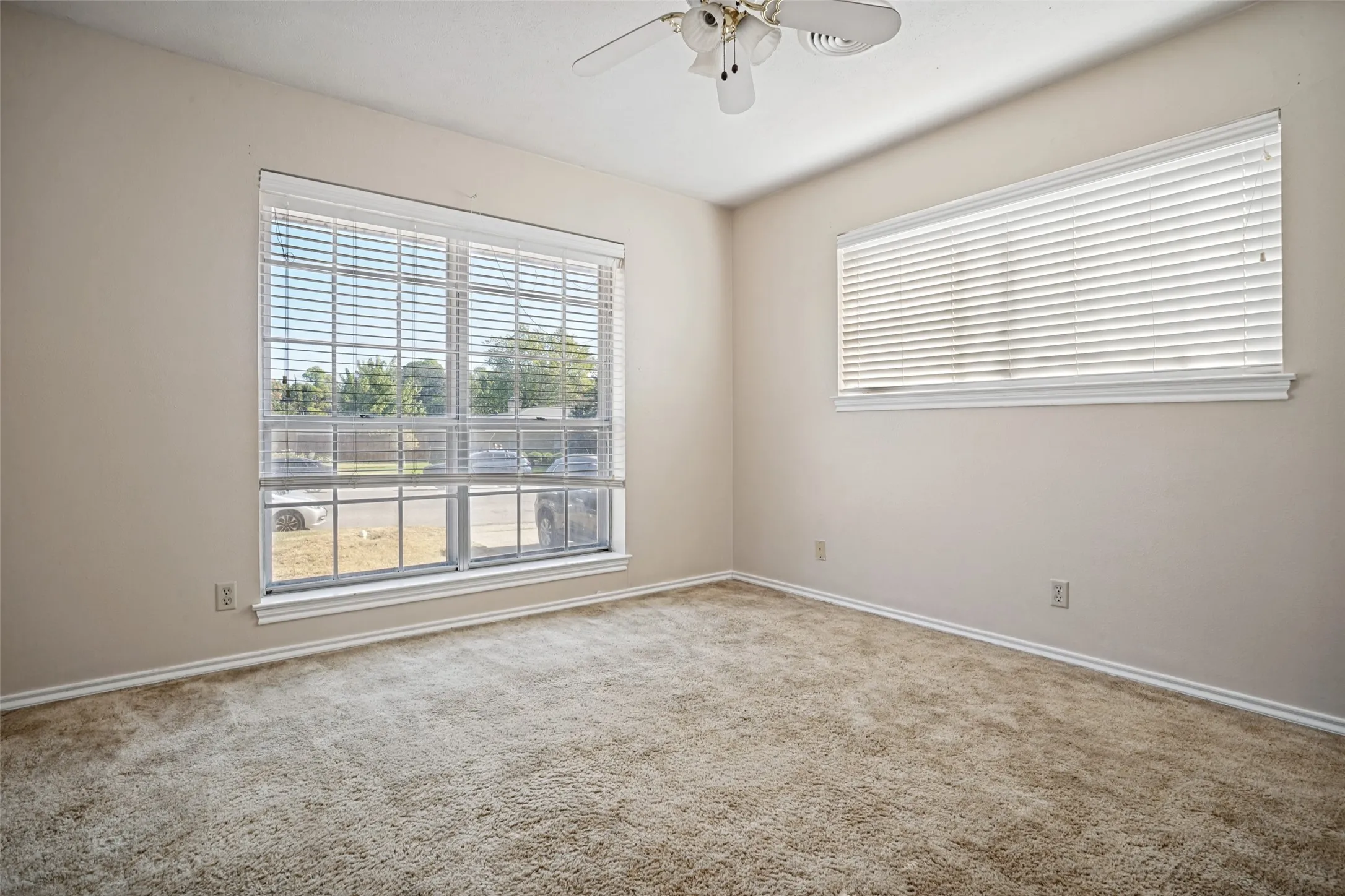 Spacious room featuring neutral carpet flooring and light-toned walls