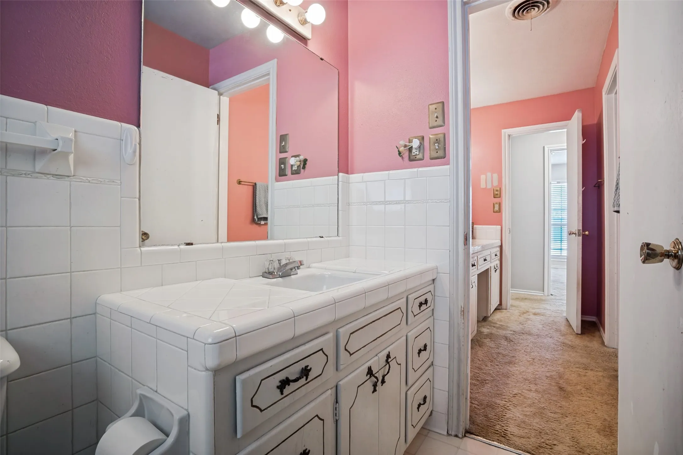 Vanity with integrated sink, white tile countertop, and lower cabinetry