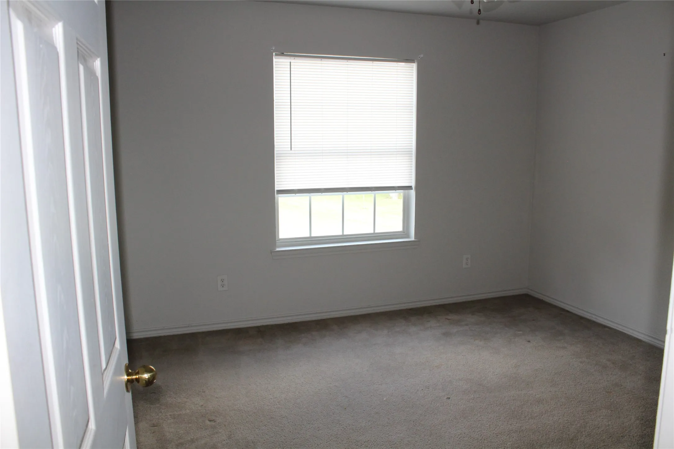 Carpeted spare room featuring baseboards