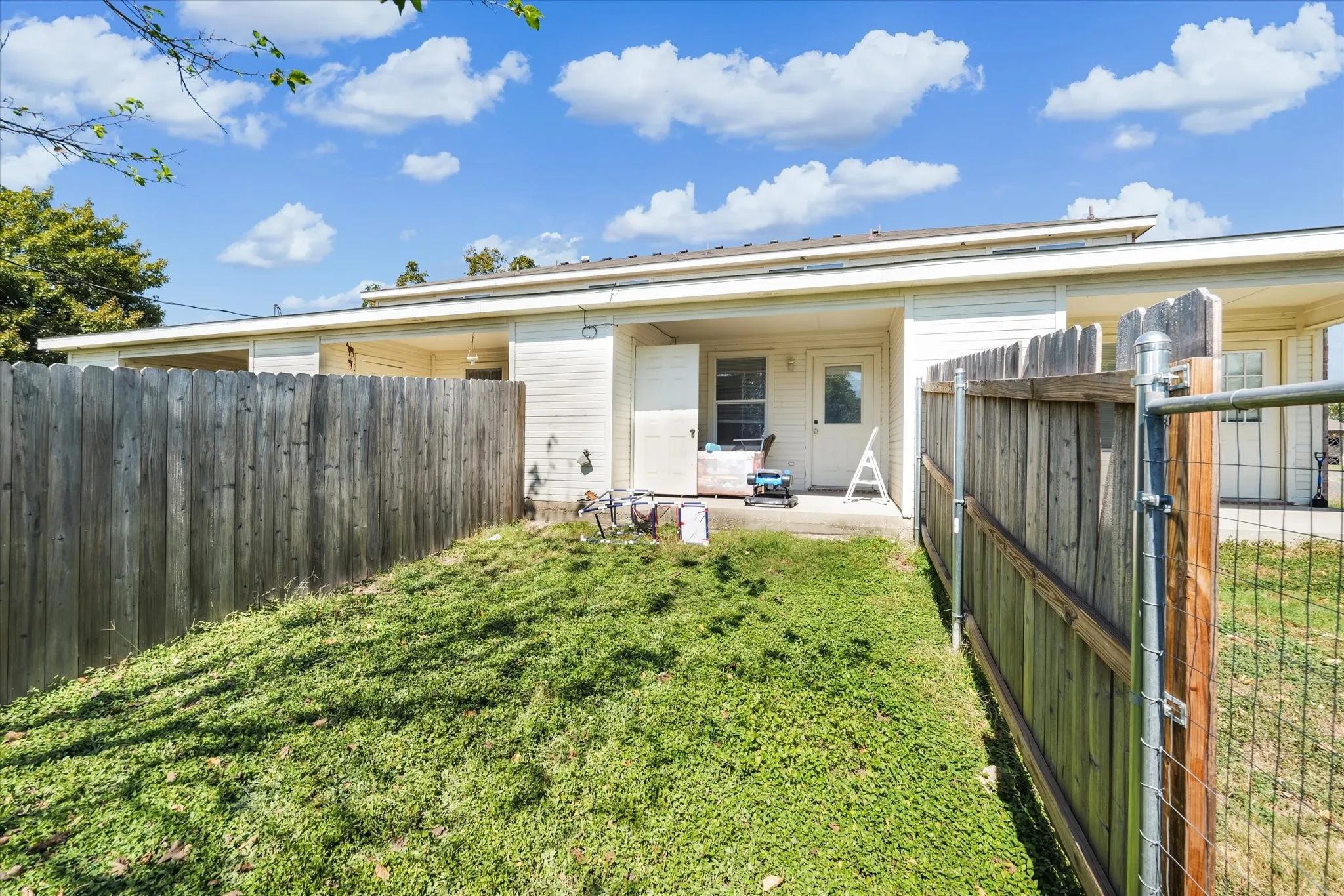 Back of property featuring a fenced backyard, a patio, and a gate