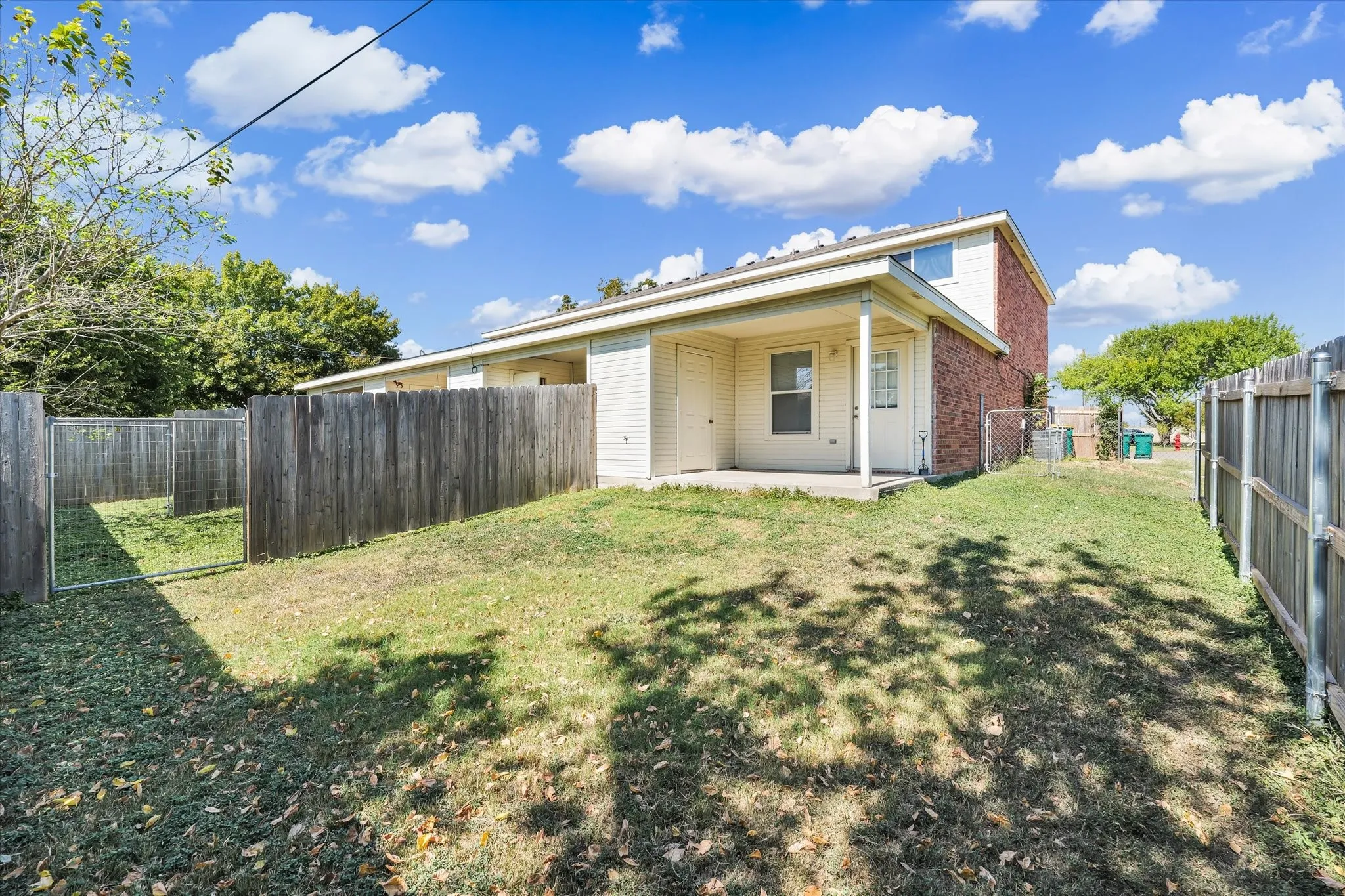 Rear view of house with a patio, a fenced backyard, and brick siding