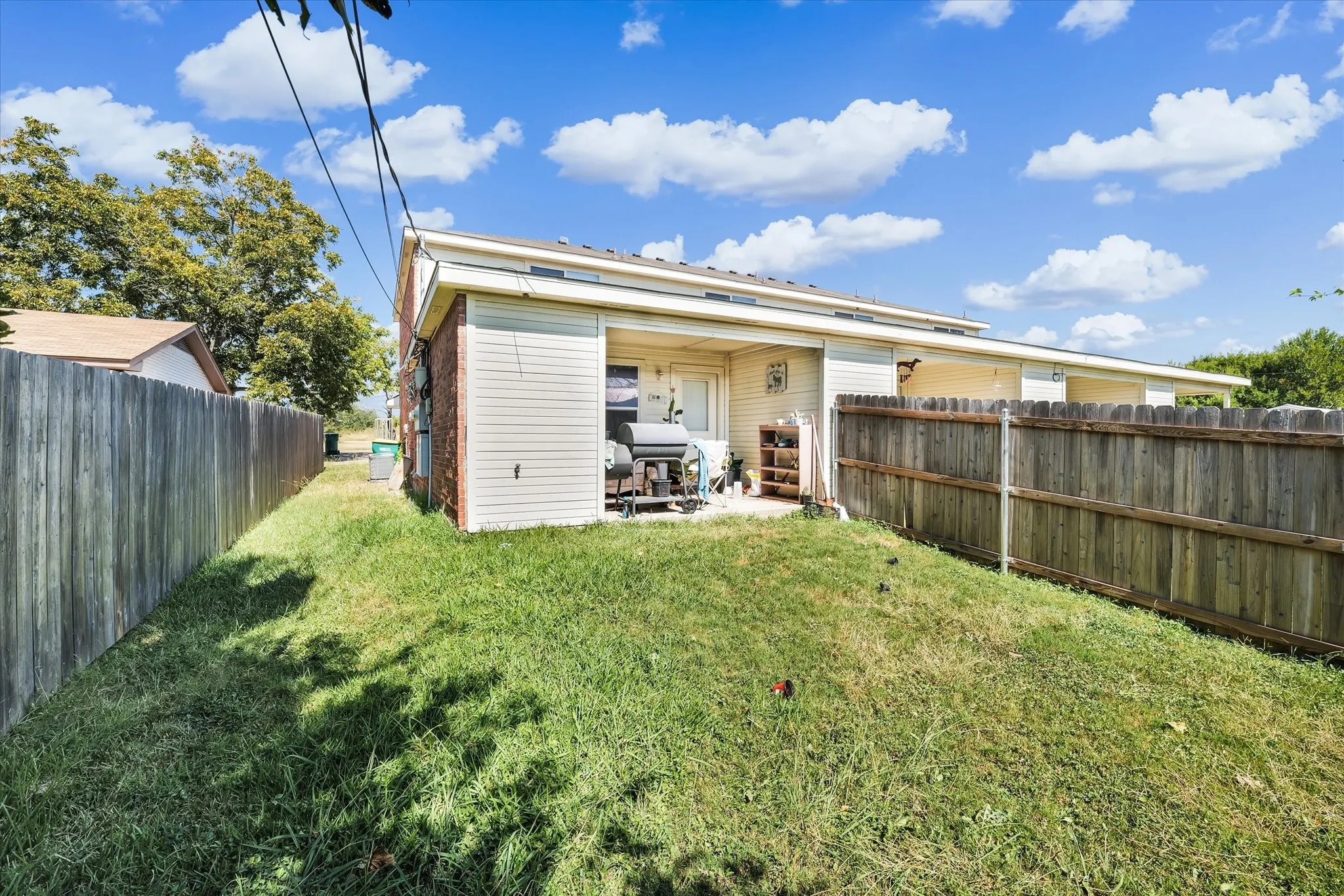 Rear view of property featuring a patio area and a fenced backyard