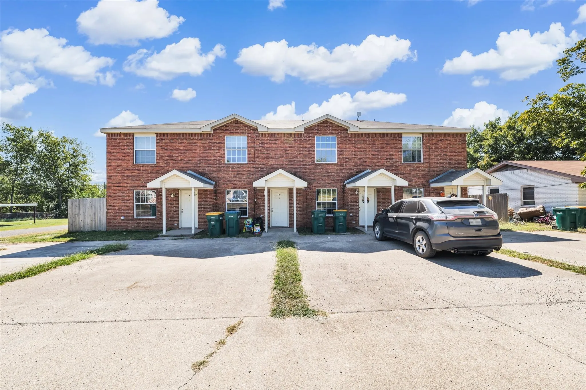 View of front of property with brick siding and concrete driveway