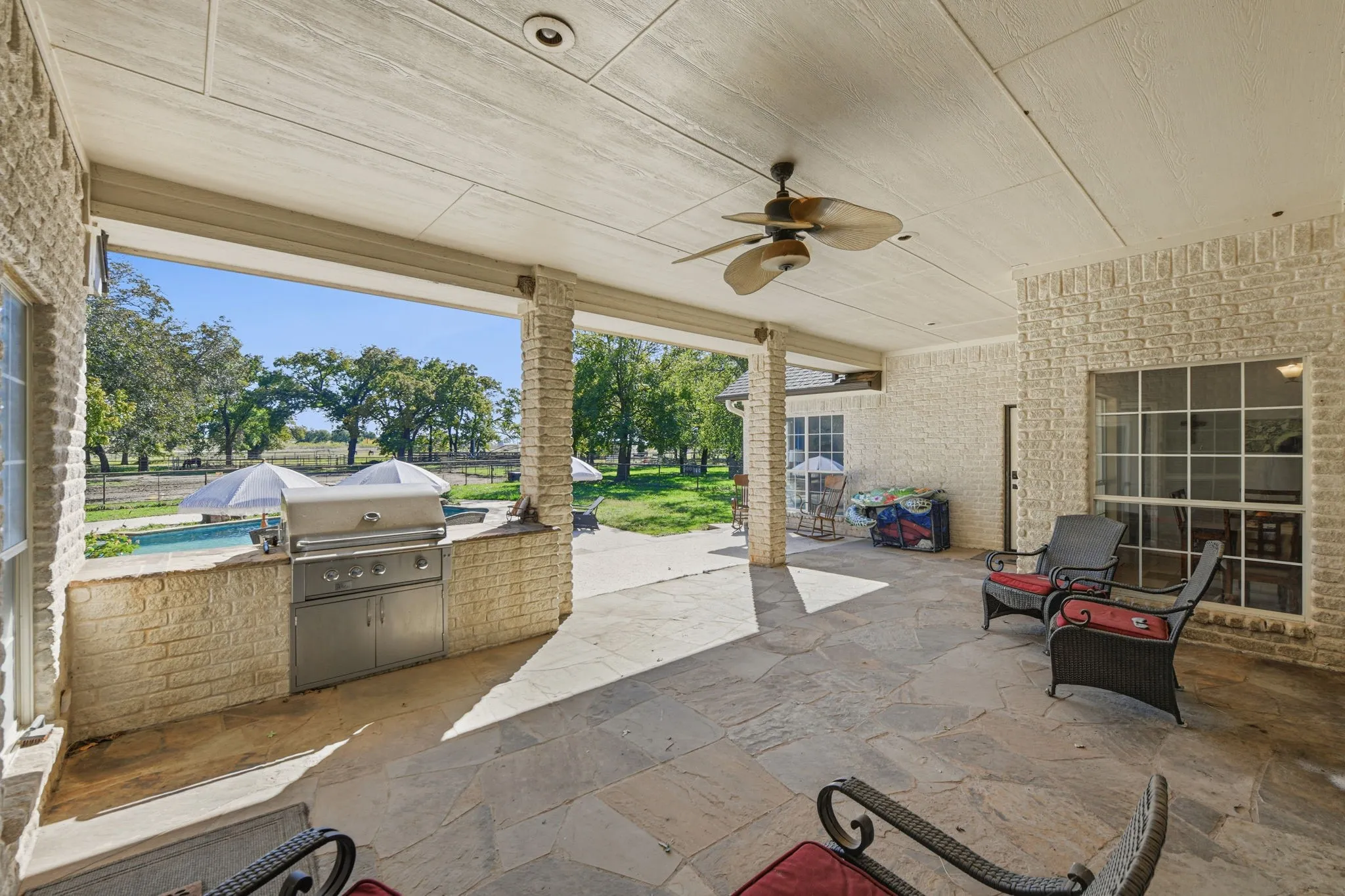 Fenced backyard with ceiling fan, a patio, and area for grilling