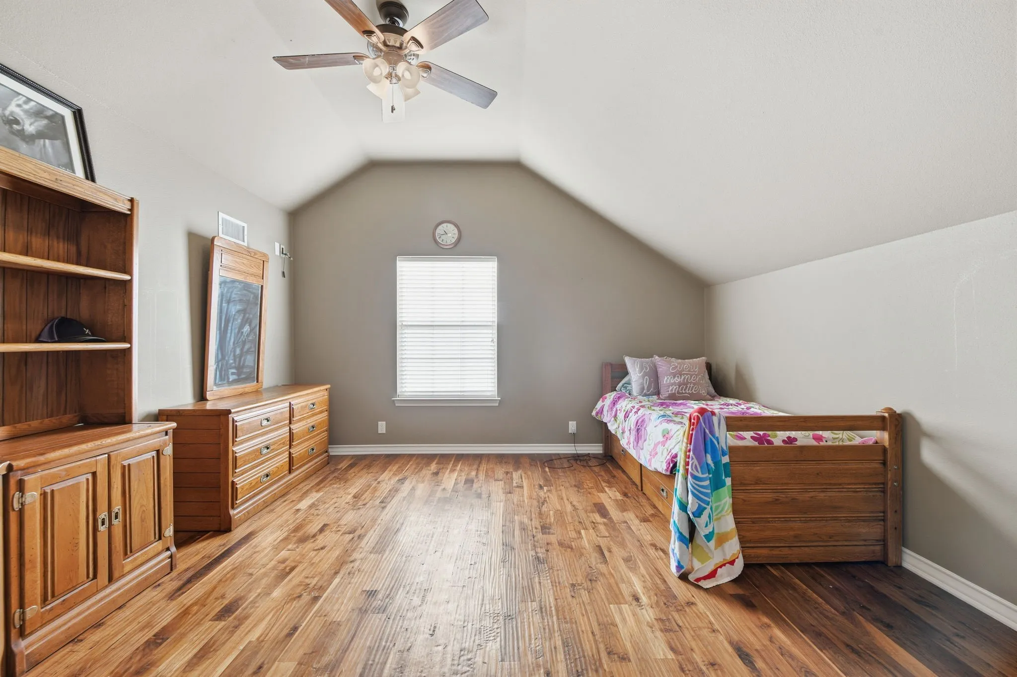 Bedroom featuring lofted ceiling, light wood-style flooring, and a ceiling fan