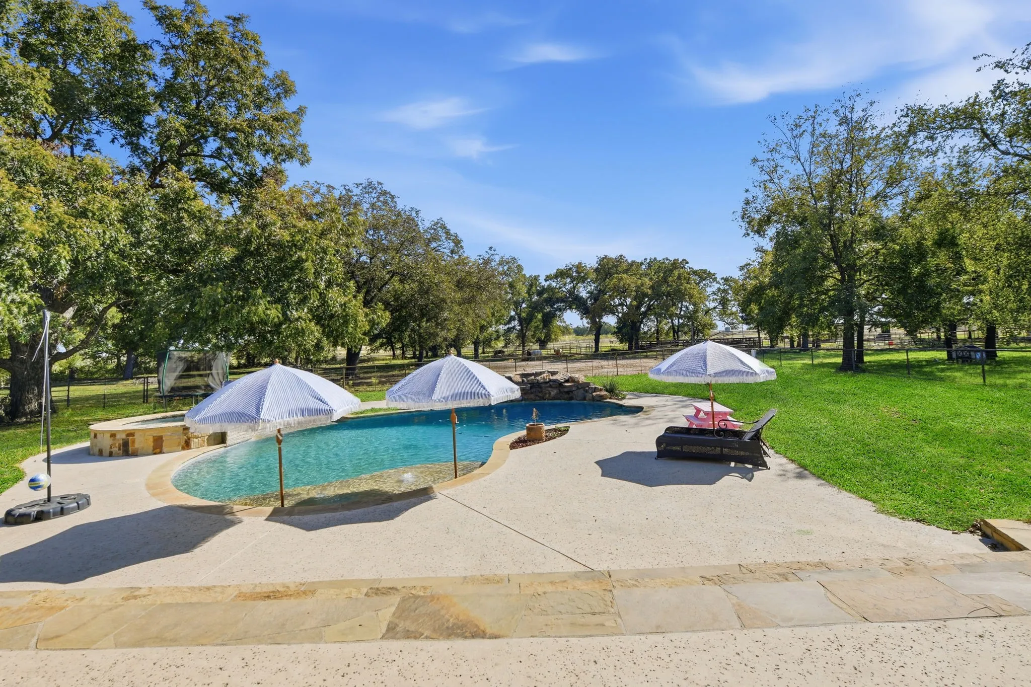 View of pool featuring a fenced backyard, a patio, and view of scattered trees