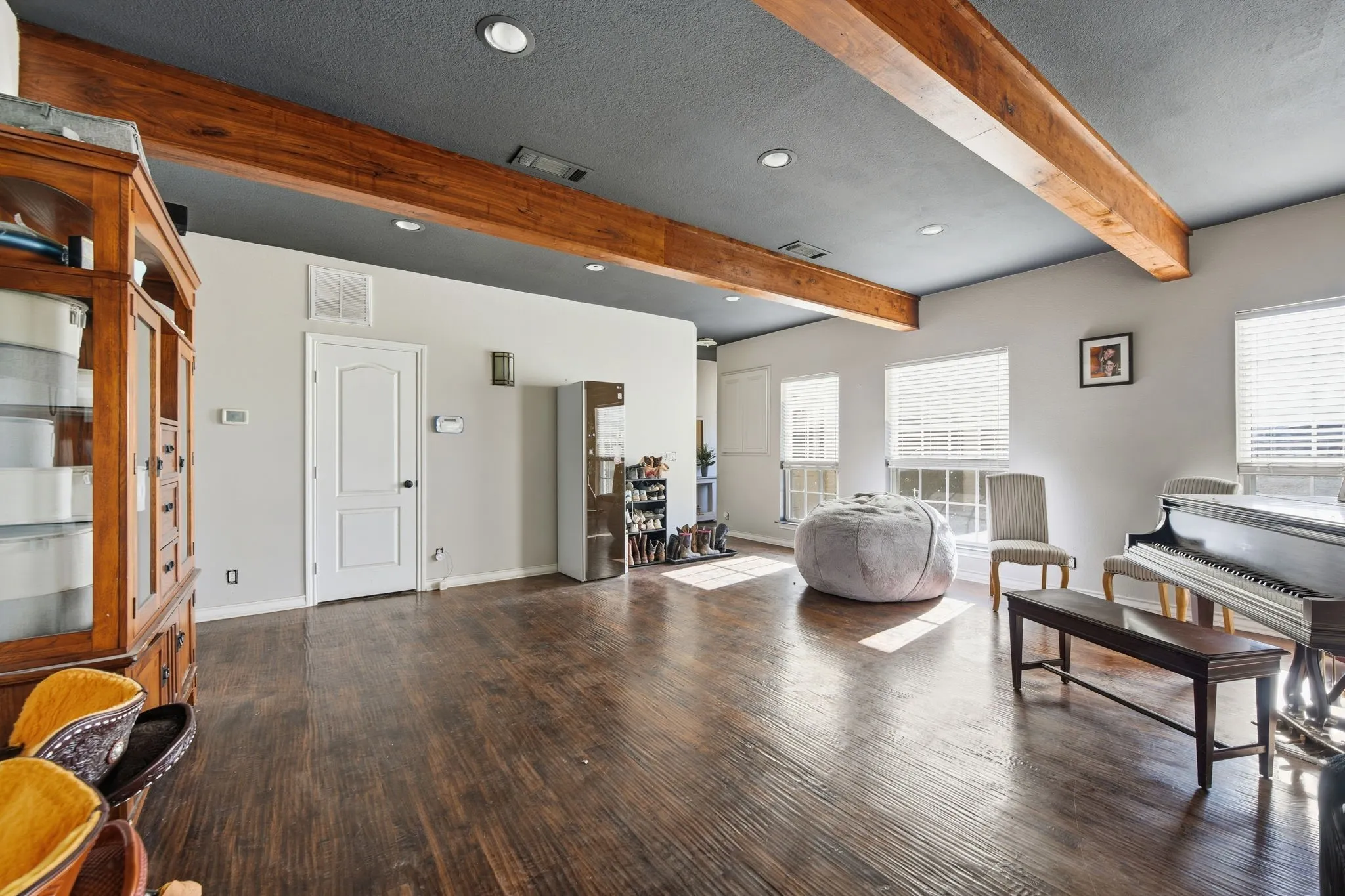 Living area with beamed ceiling, recessed lighting, dark wood-style floors, and a textured ceiling