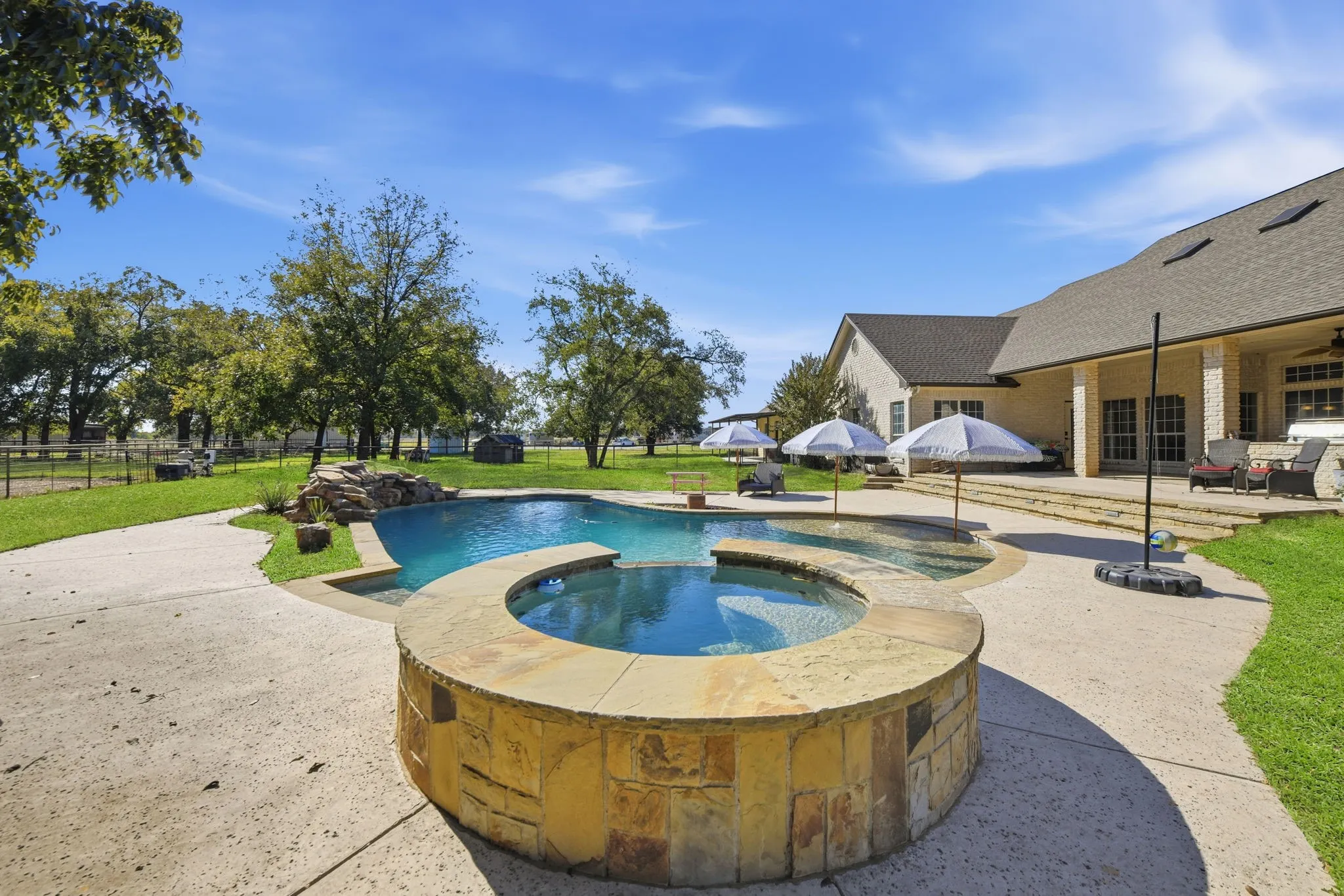 View of swimming pool featuring a patio area and a pool with connected hot tub