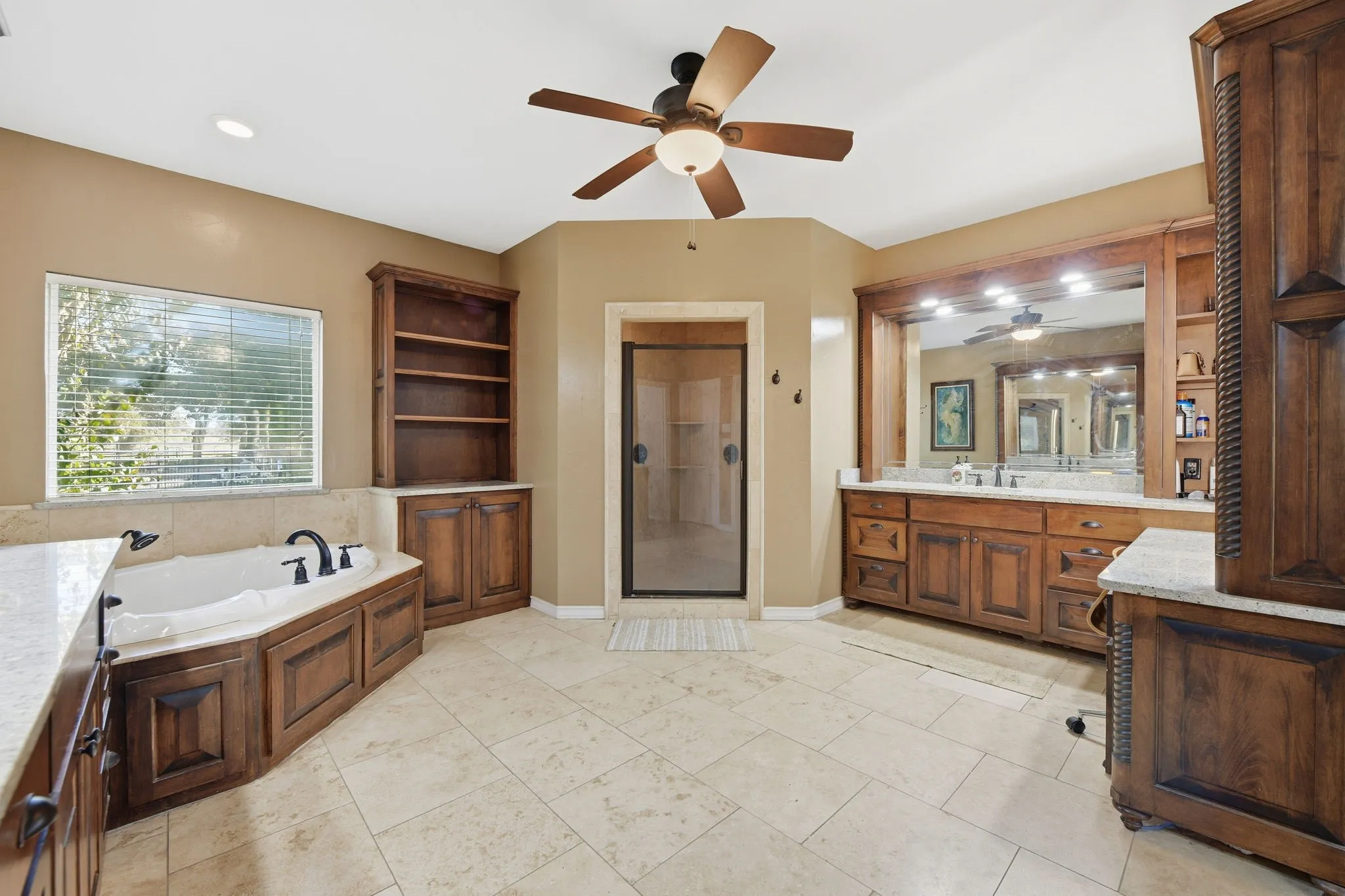 Bathroom with vanity, a shower stall, a garden tub, ceiling fan, and recessed lighting