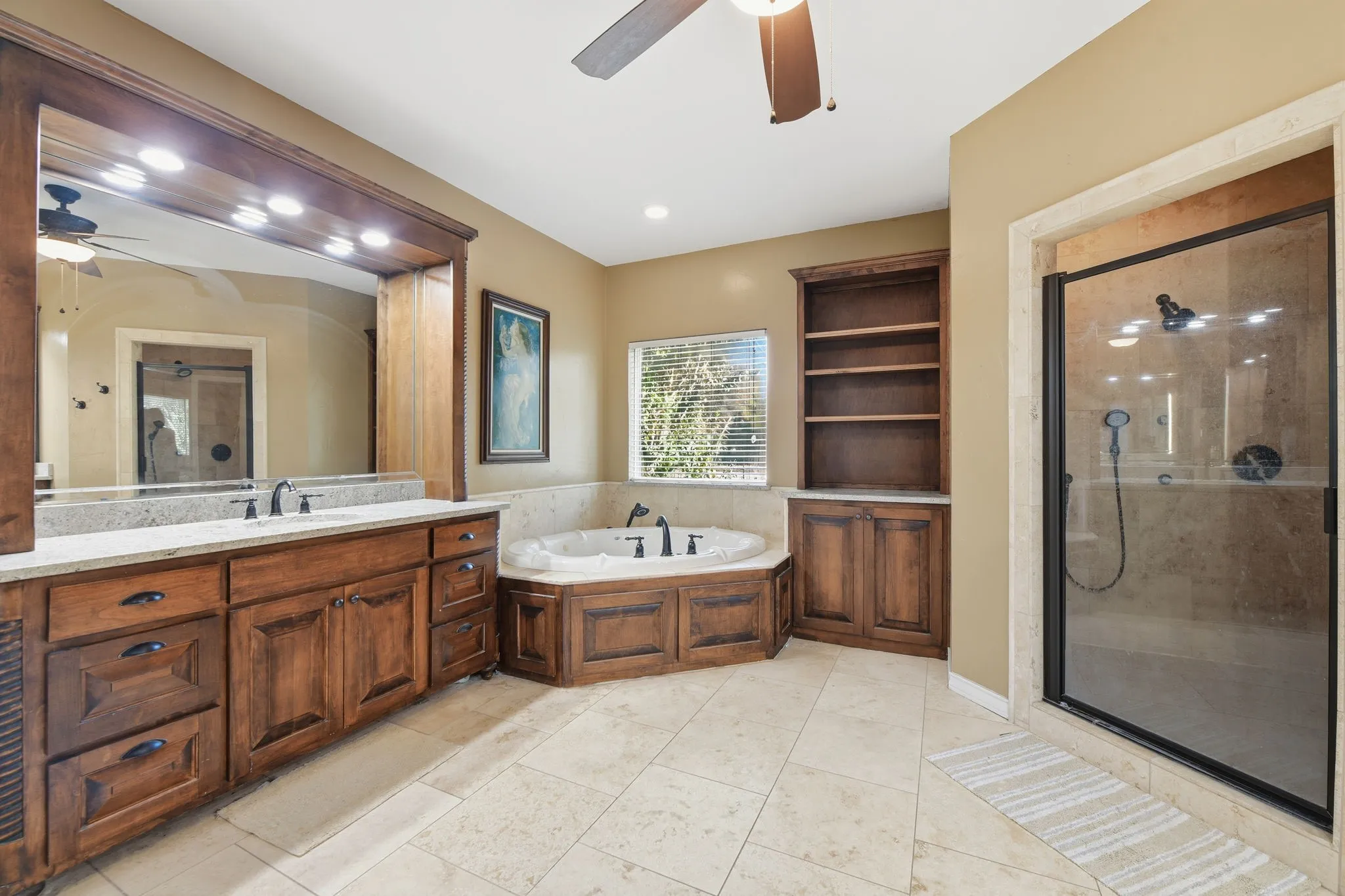 Bathroom featuring a ceiling fan, a garden tub, vanity, a stall shower, and light tile patterned floors