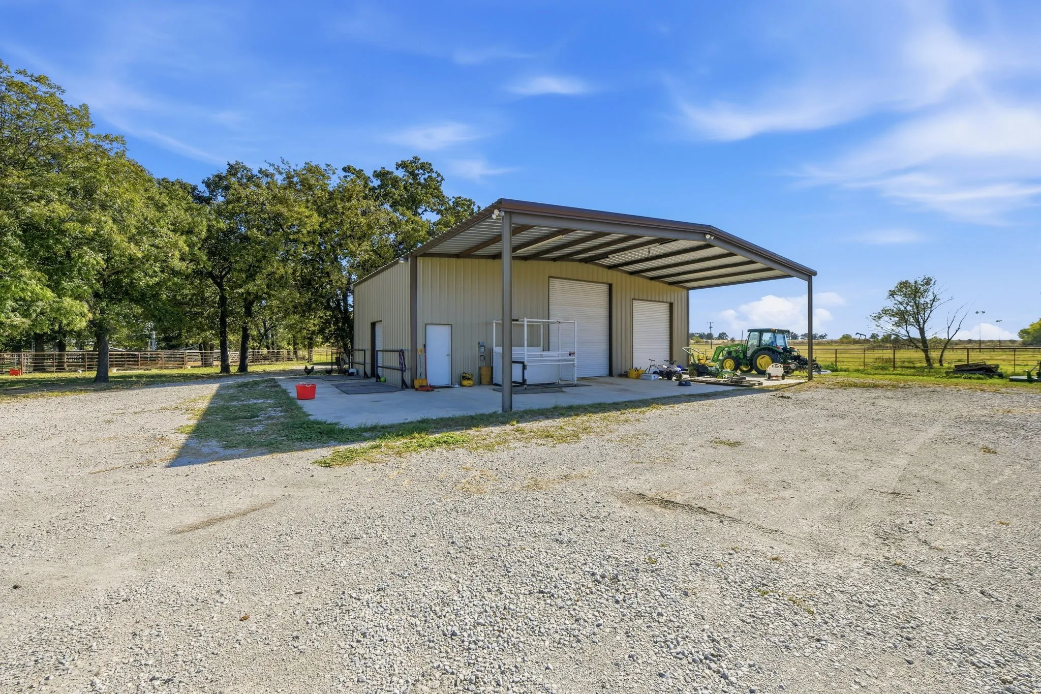 View of parking / parking lot featuring a garage and an outbuilding