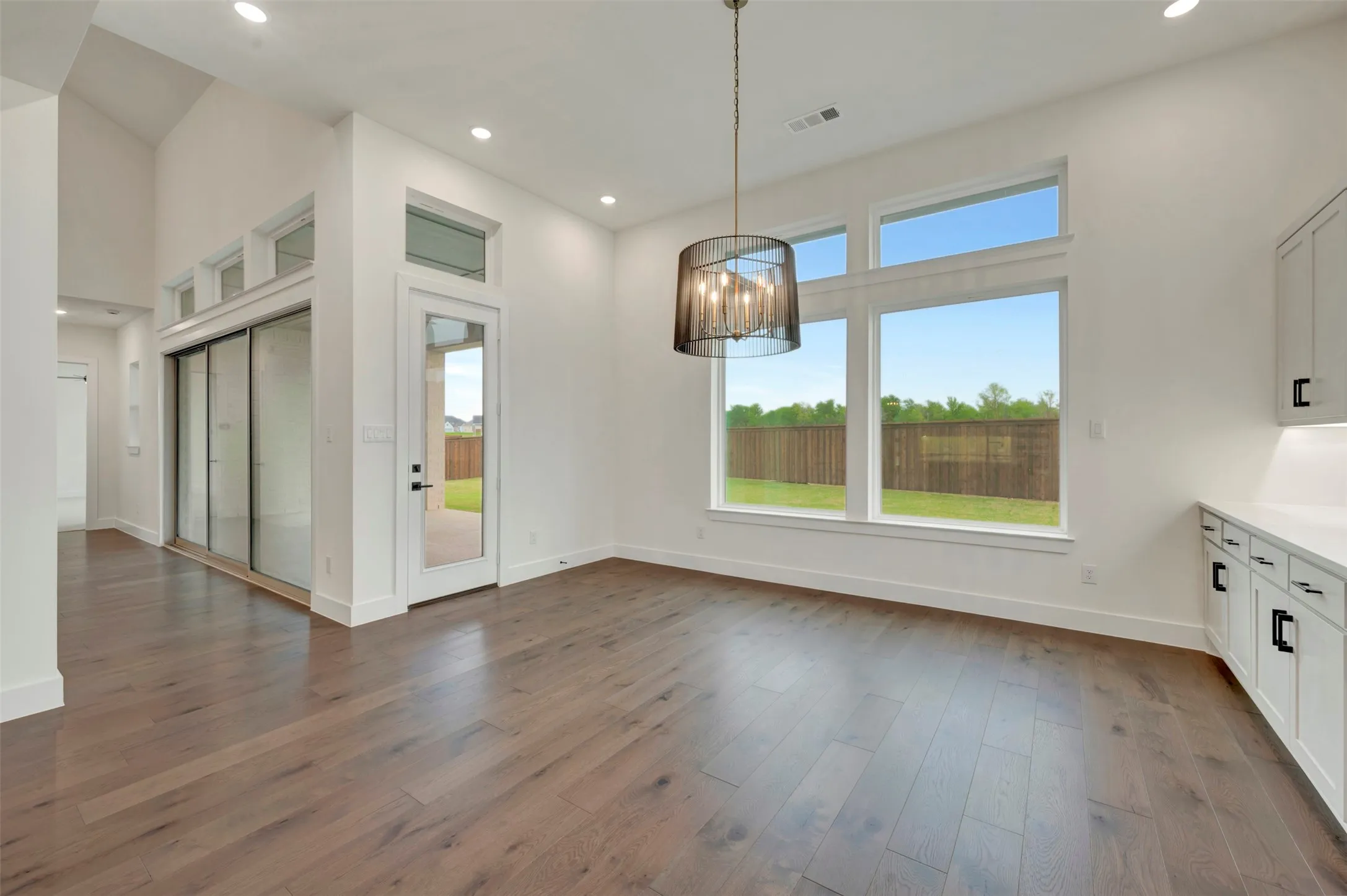 Dining area with a chandelier, dark wood-style floors, and plenty of natural light