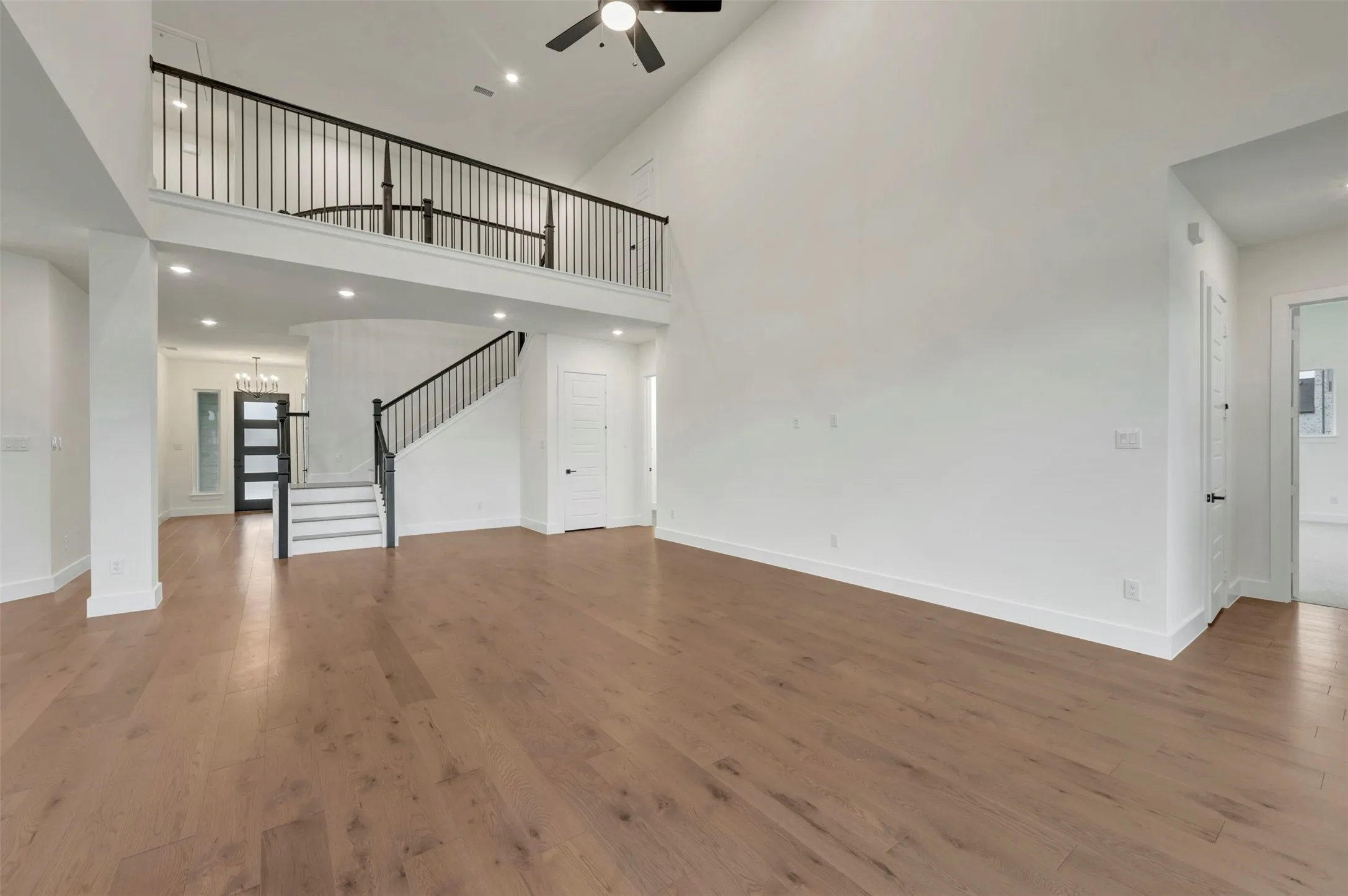 Living room featuring recessed lighting, dark wood-type flooring, a high ceiling, and a ceiling fan