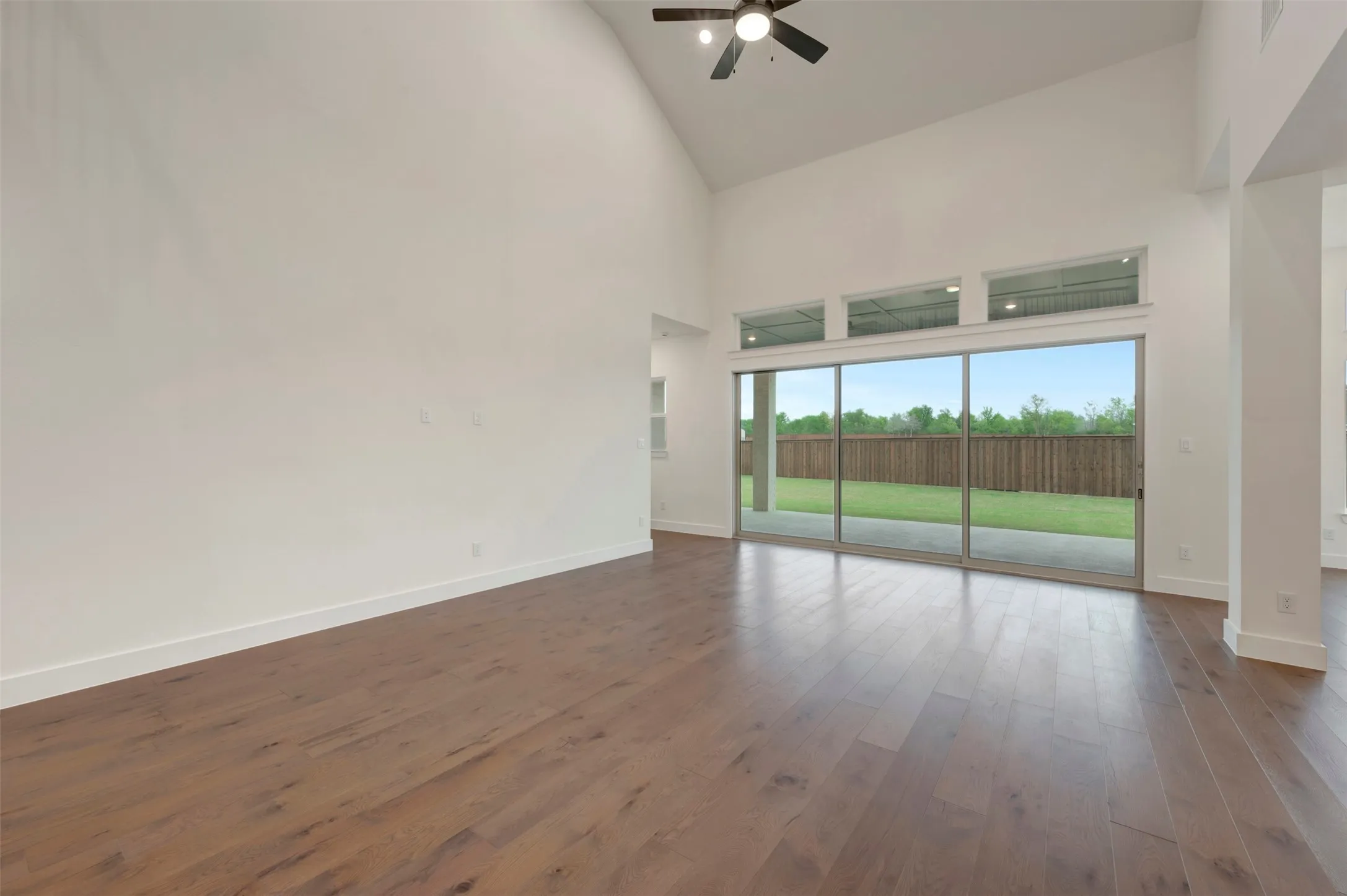 Family Room featuring a ceiling fan, dark wood-style floors, and lofted ceiling
