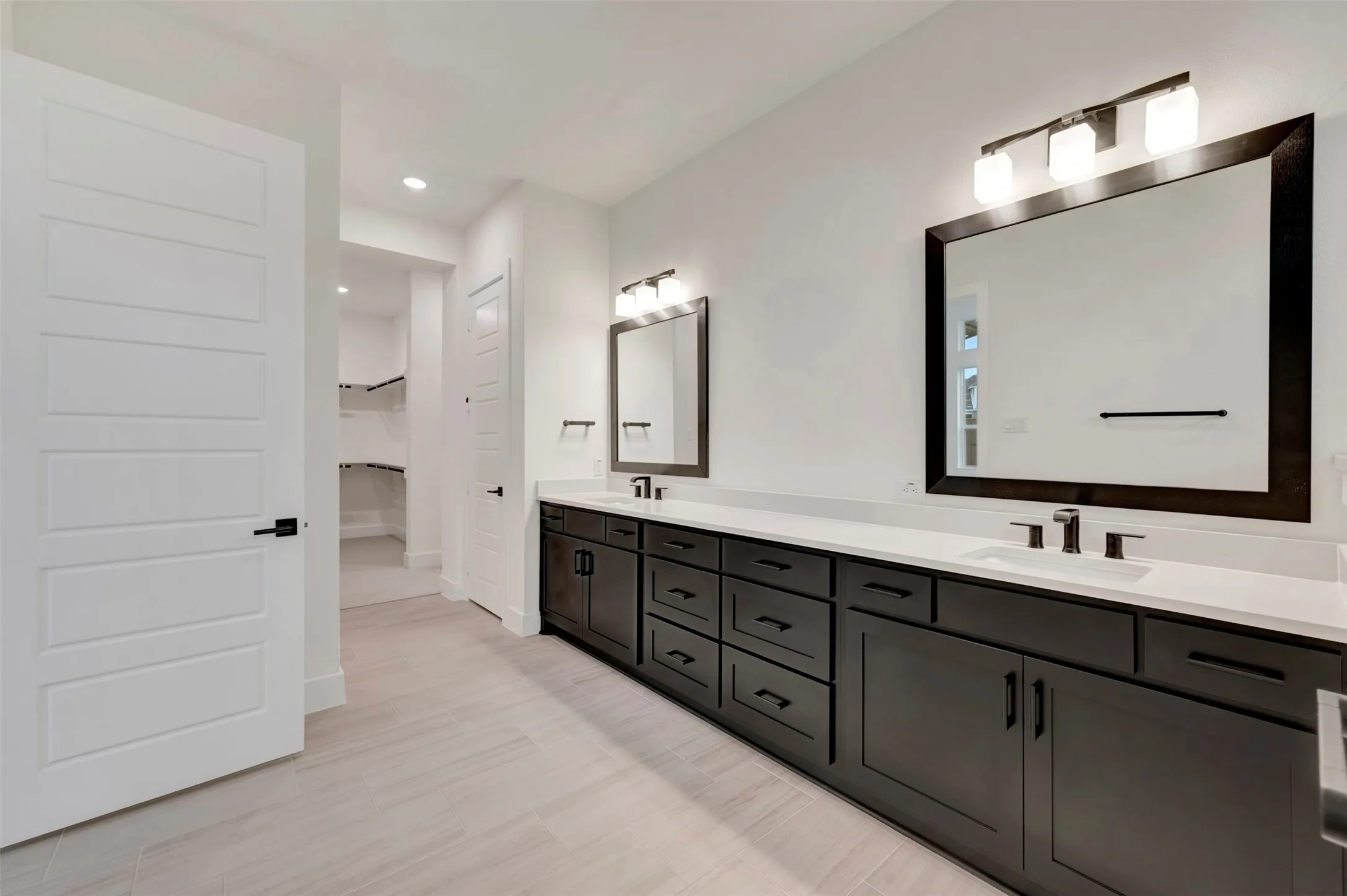 Owners bath featuring double vanity, recessed lighting, and light wood-style flooring
