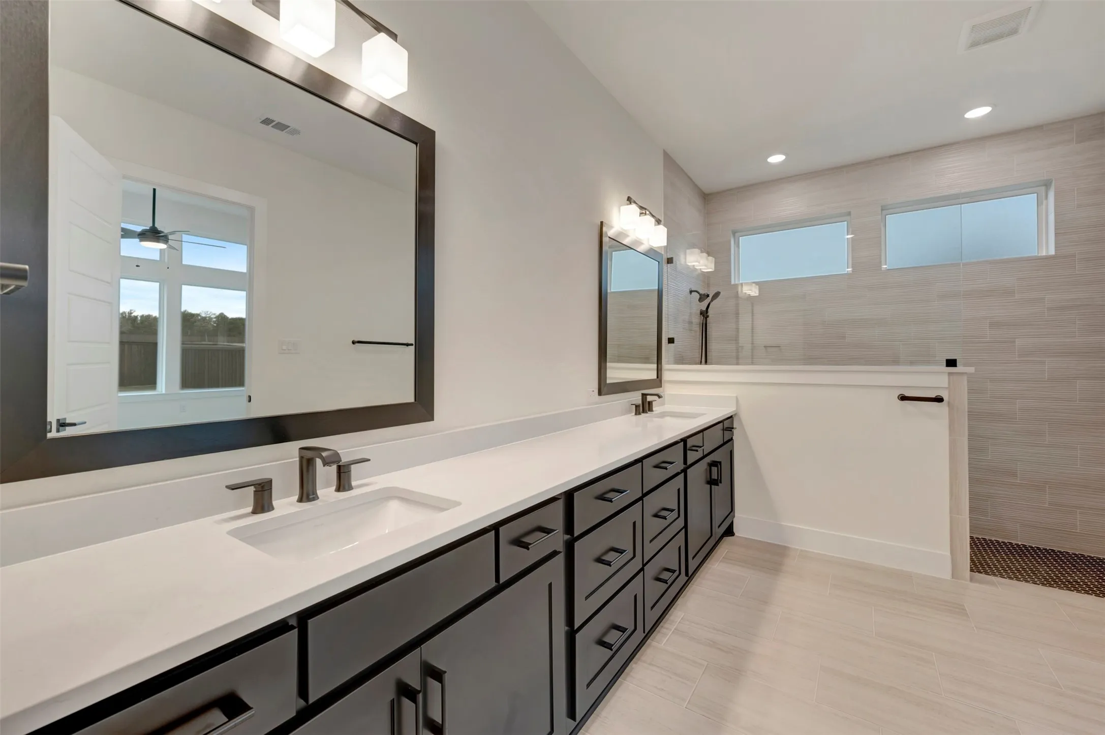 Owners Bathroom with double vanity, walk in shower, and recessed lighting