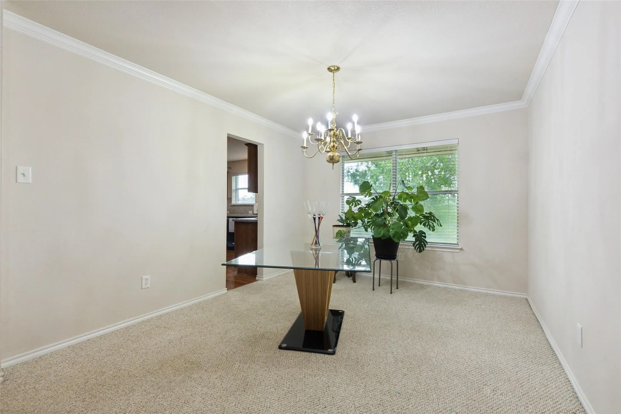 Unfurnished dining area with ornamental molding, carpet, and a chandelier